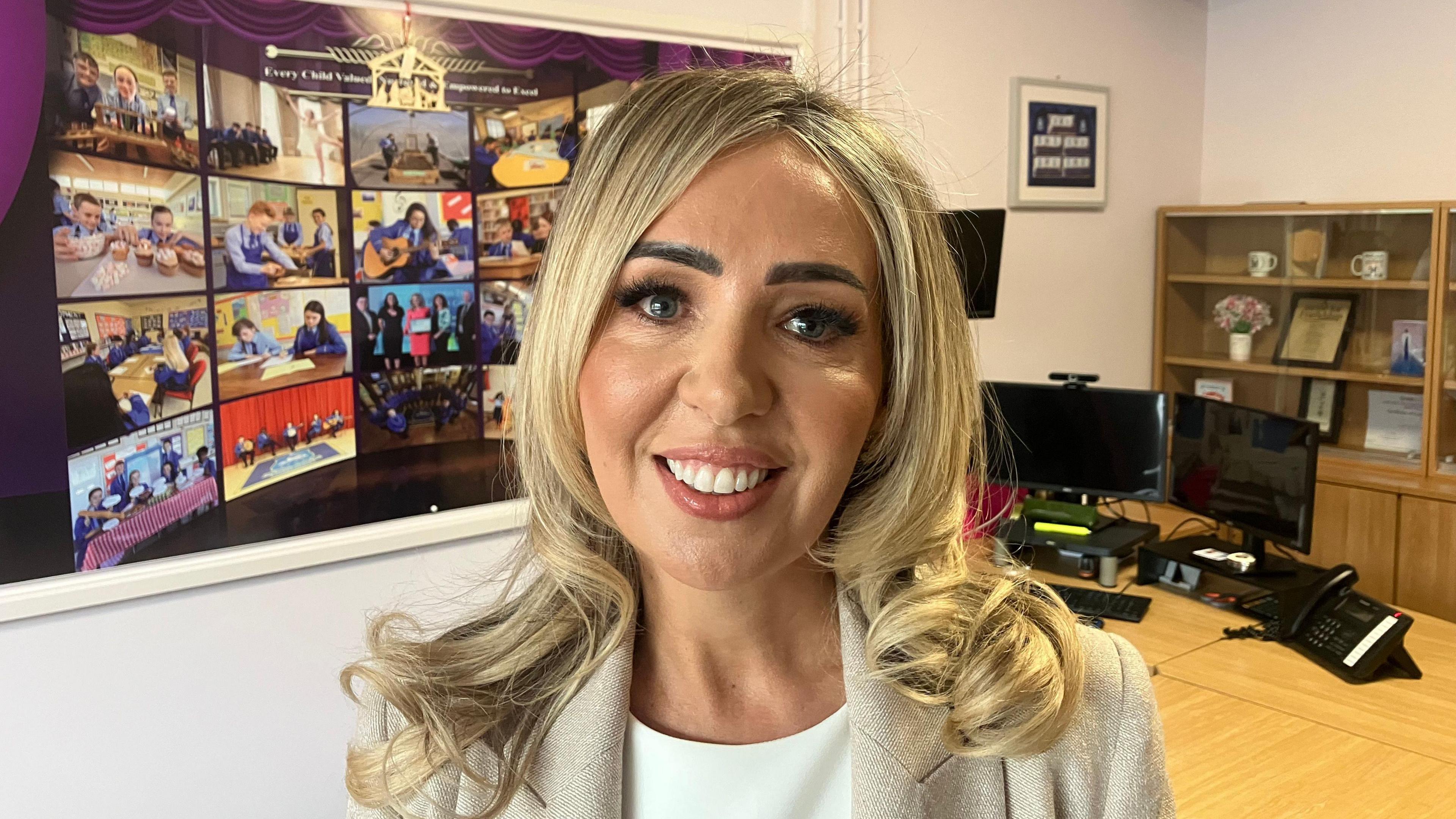 Noella Murphy. She has long blonde hair, wearing a cream blazer and white top.