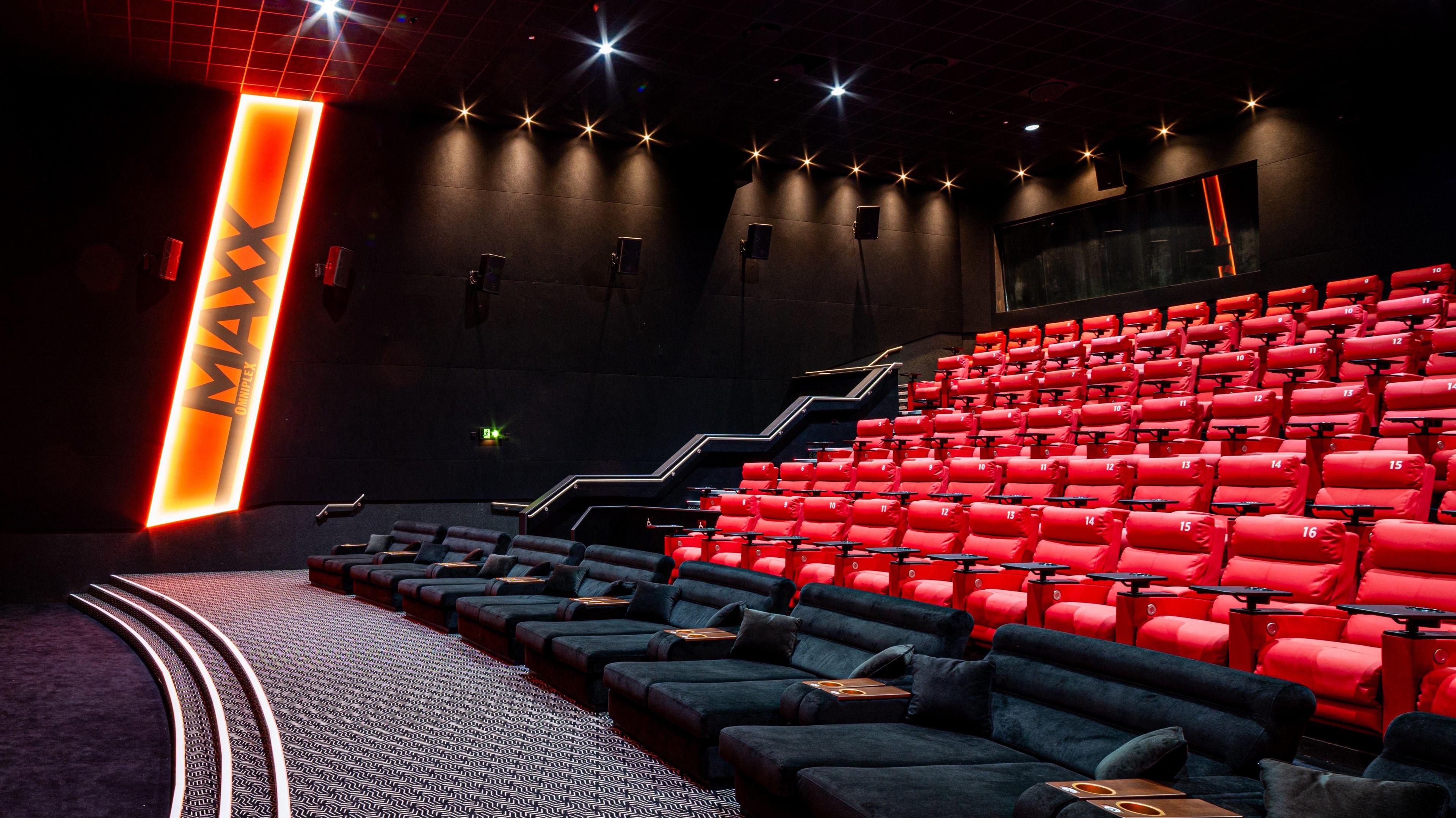 A cinema auditorium with plush black and red seats