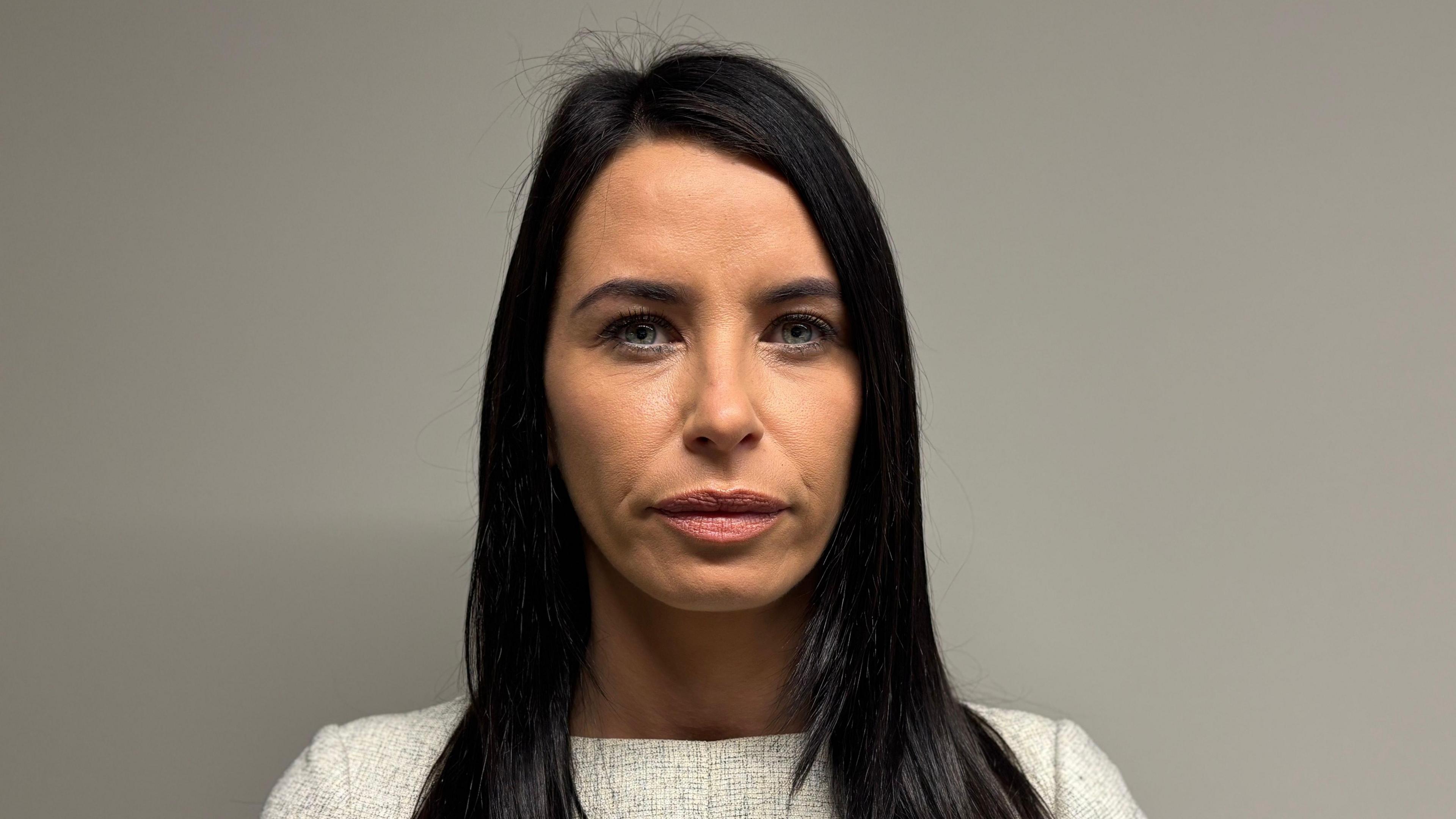 Sheree Black. She has long black hair and blue eyes, wearing a cream jumper, looking directly at the camera