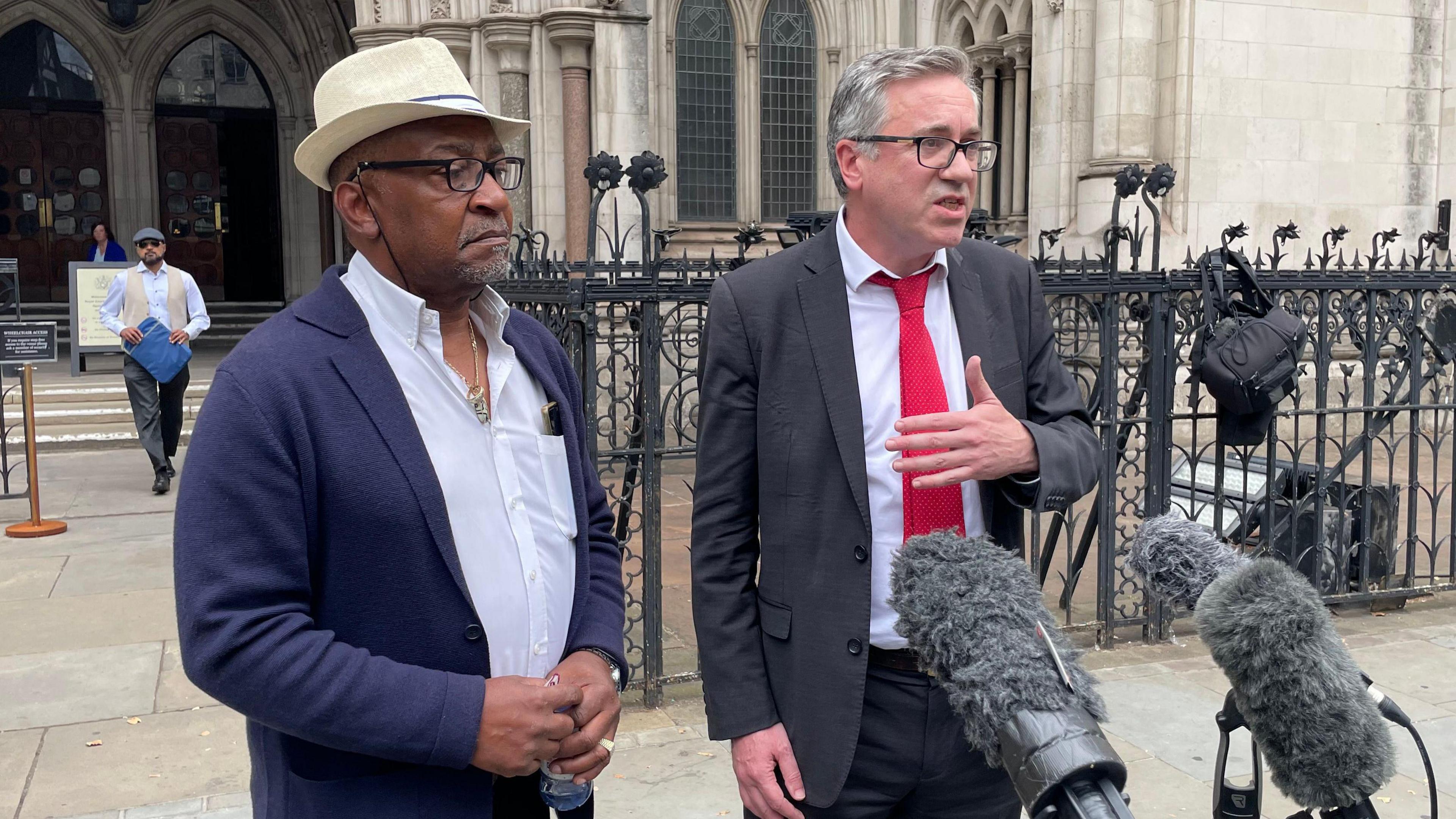 Errol Campbell Jr, the son of Errol Campbell, and solicitor Matt Foot standing outside the court.