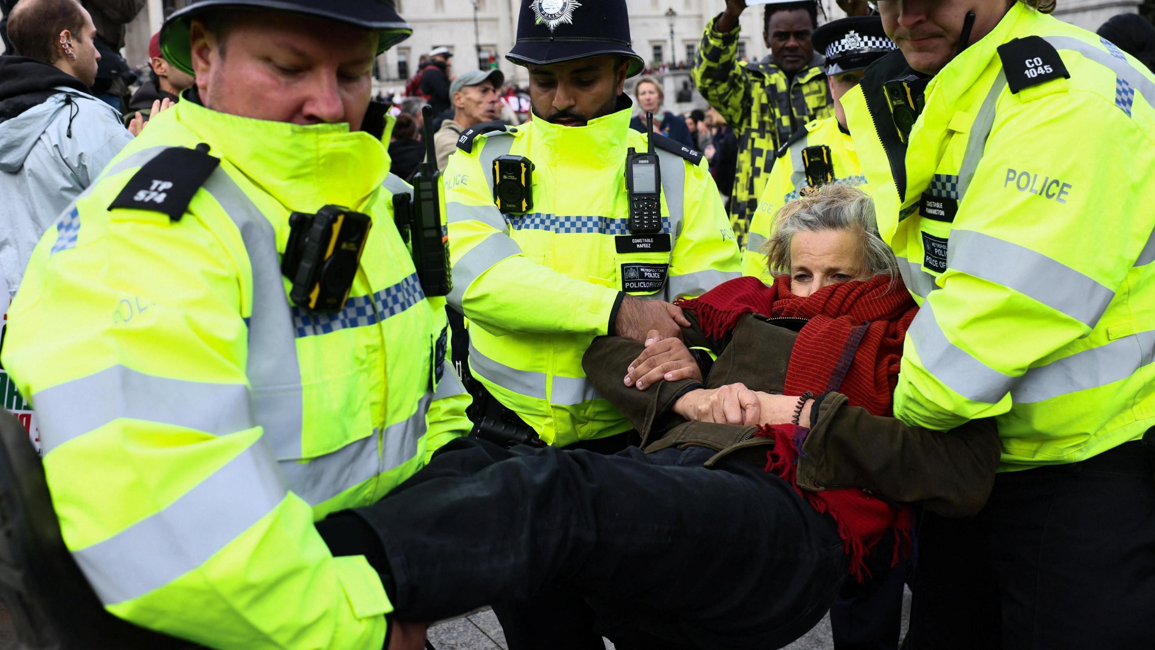 Police officers detain a protester during a mass demonstration organised by Defend our Juries
