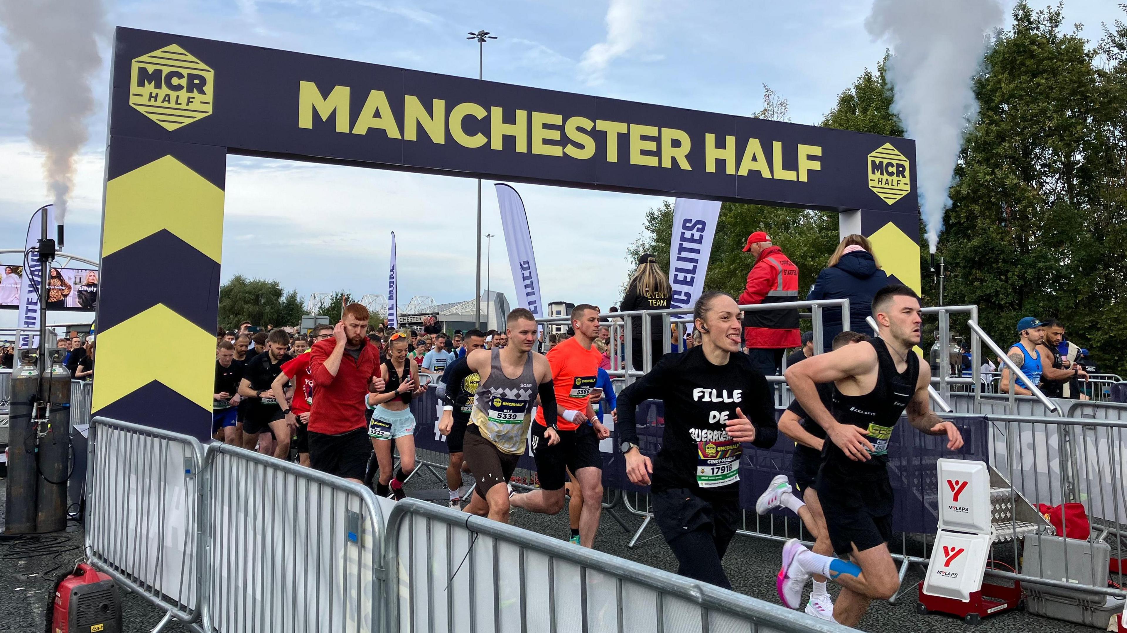 Runners set off under a black and yellow start sign