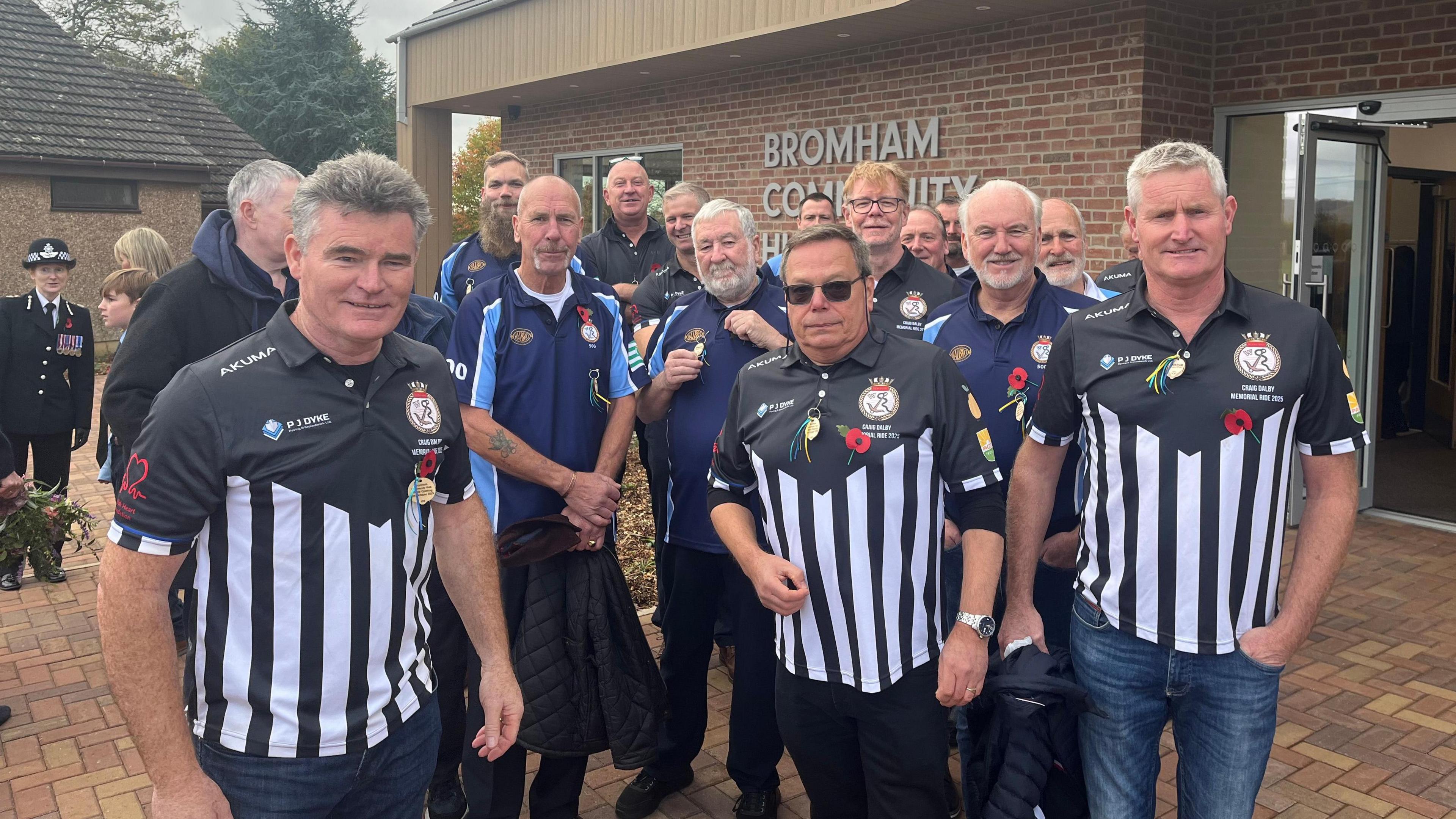 A group of men smile at the camera and wear black and white shirts
