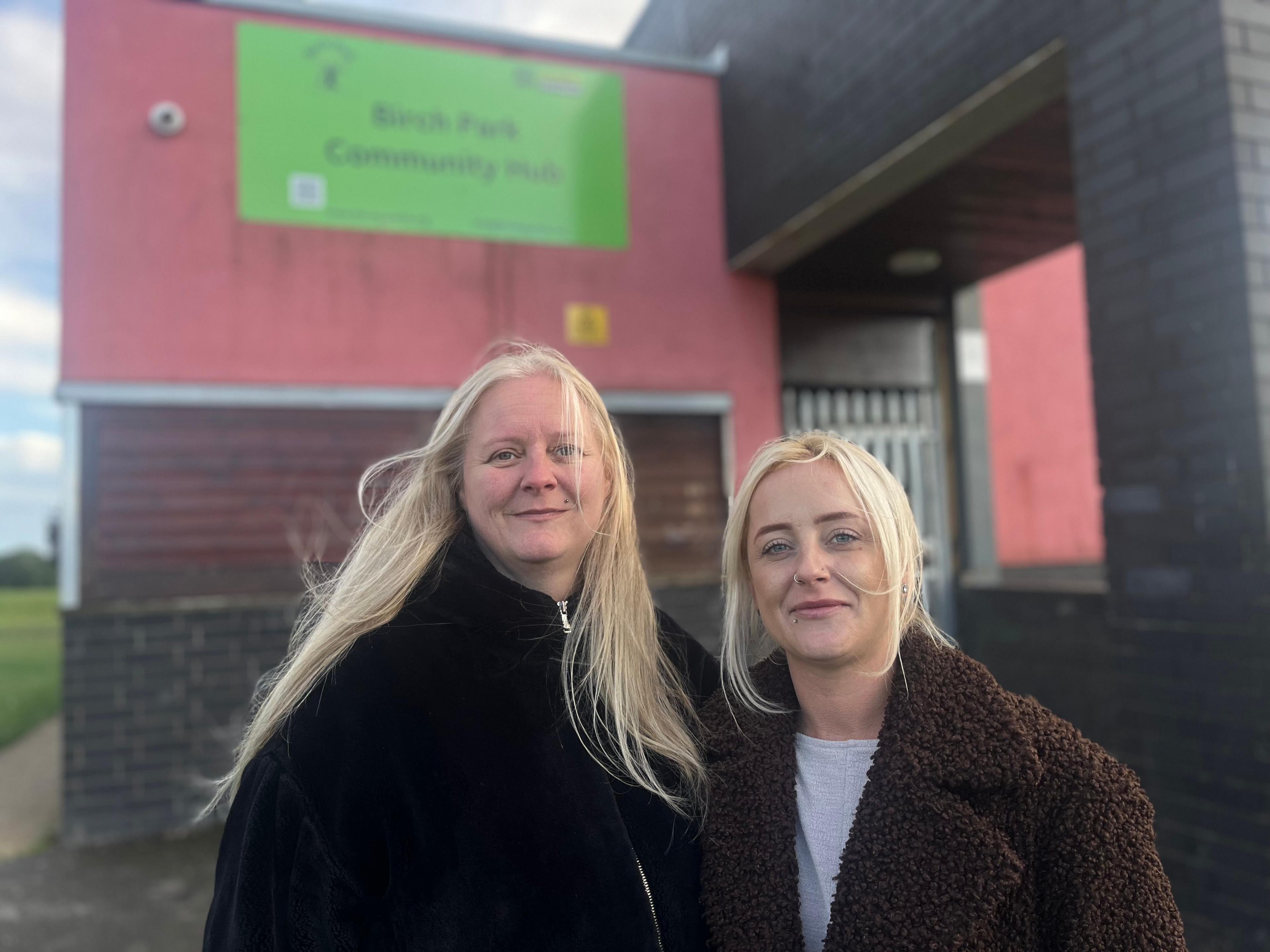 Sarah Elliott and Kylie Beadsworth, pictured left to right while smiling outside the youth centre in Bilborough. Ms Elliott is wearing a black coat, while Kylie Beadswirth is wearing a brown furry coat.