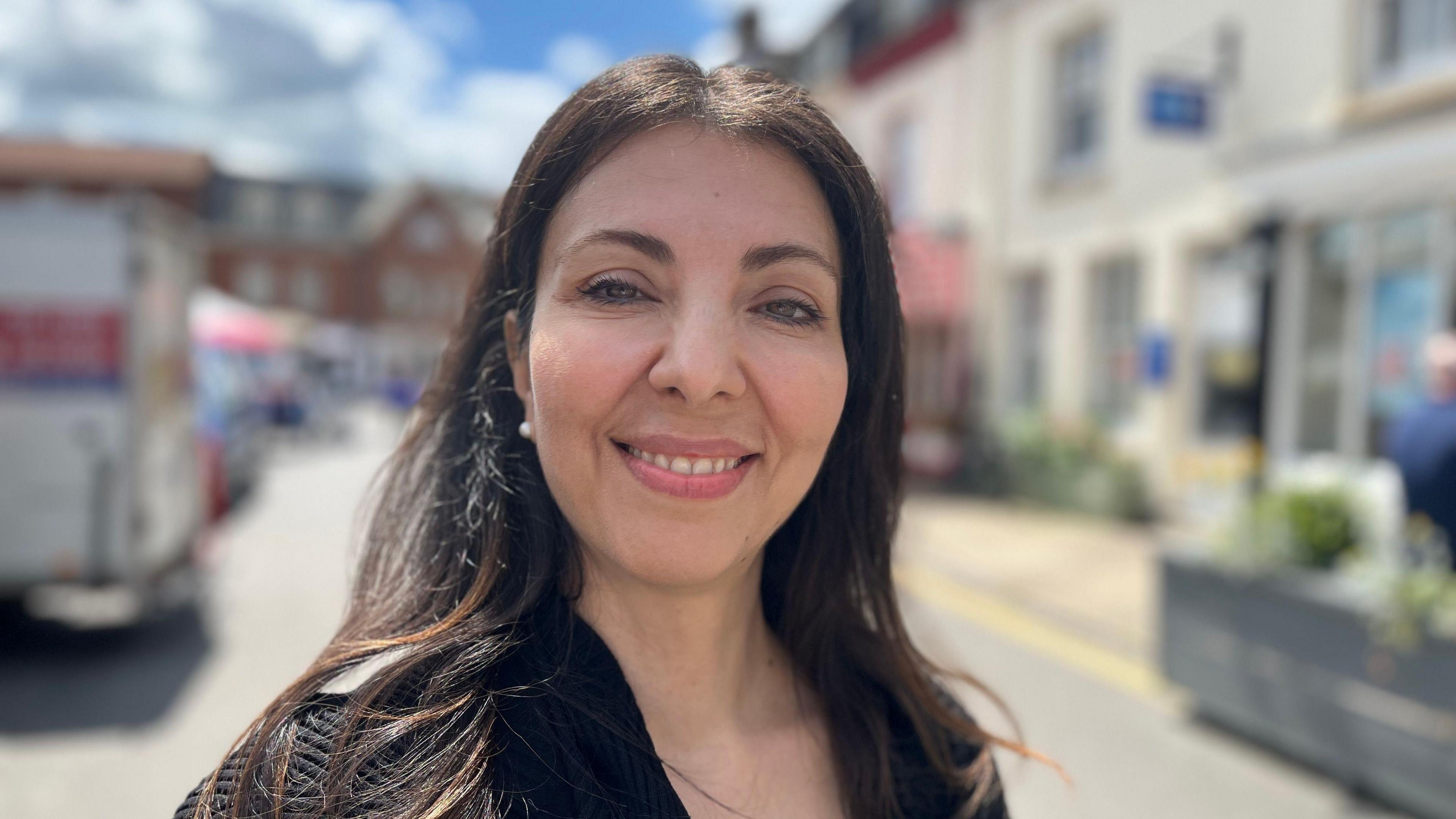 Dr Leyla Hannbeck smiling while standing on a High Street