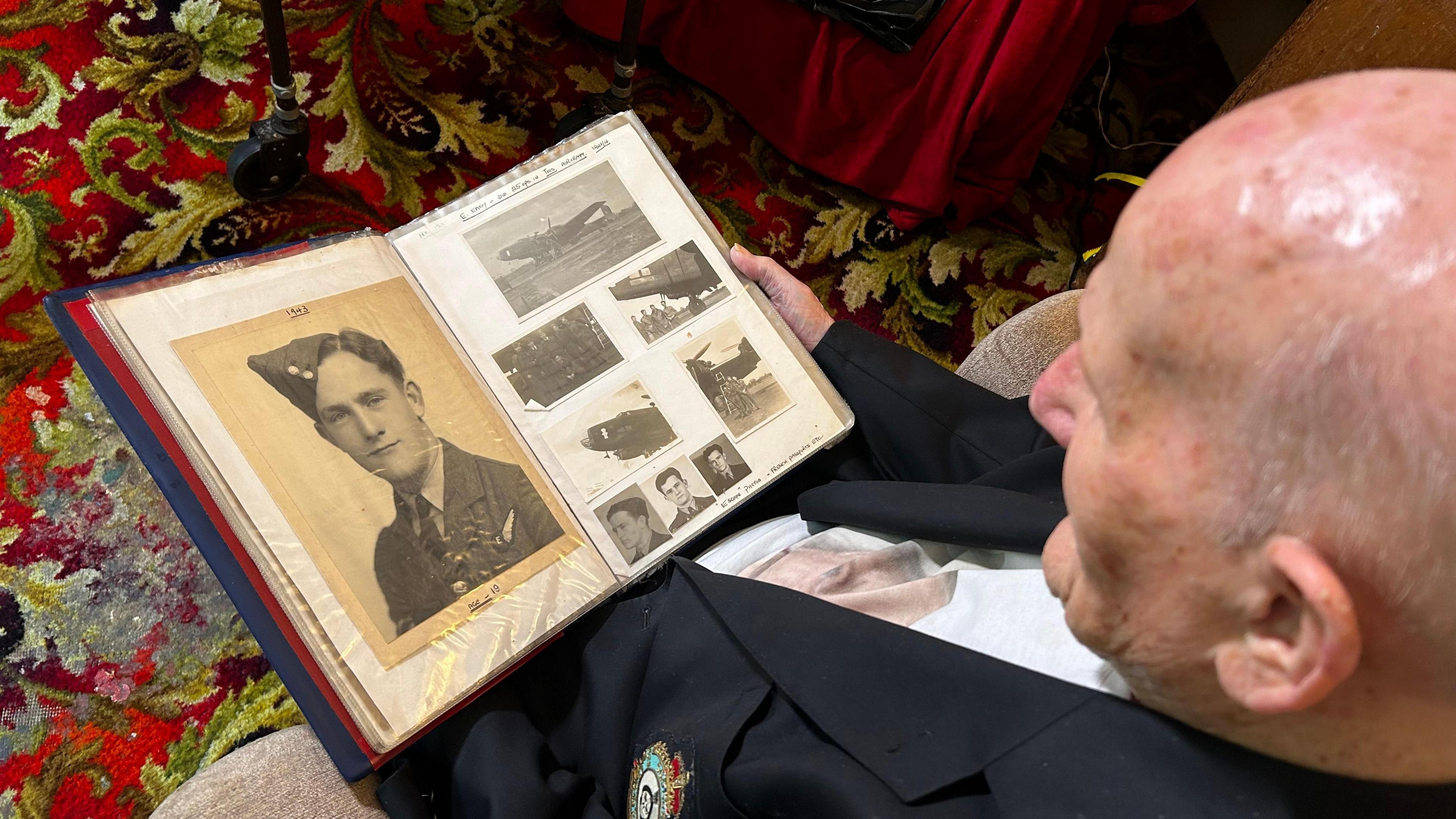 Jack Warner looking at scrapbook