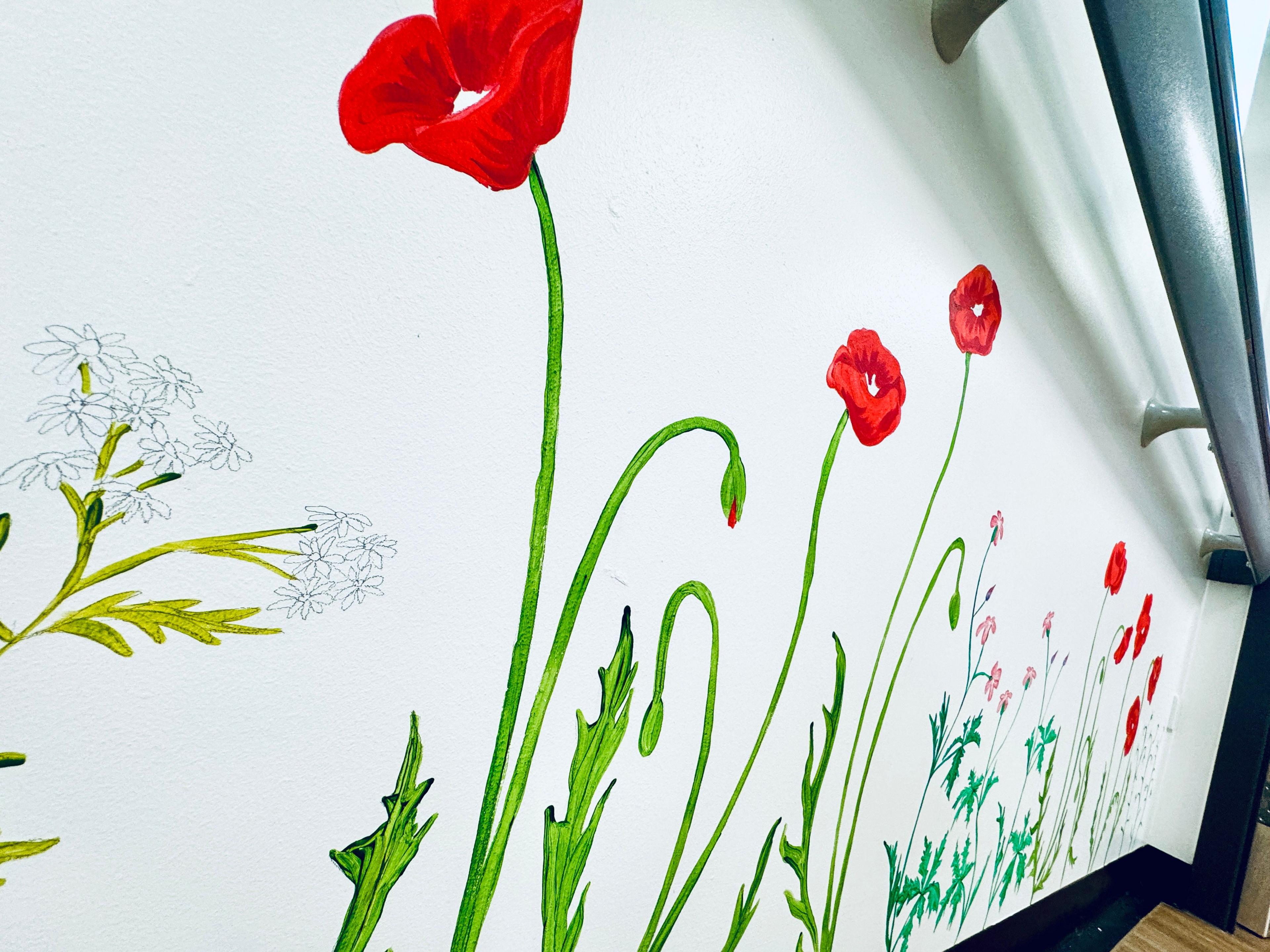 White hospital wall embellished with paintings of red poppies and other beautiful wild flowers