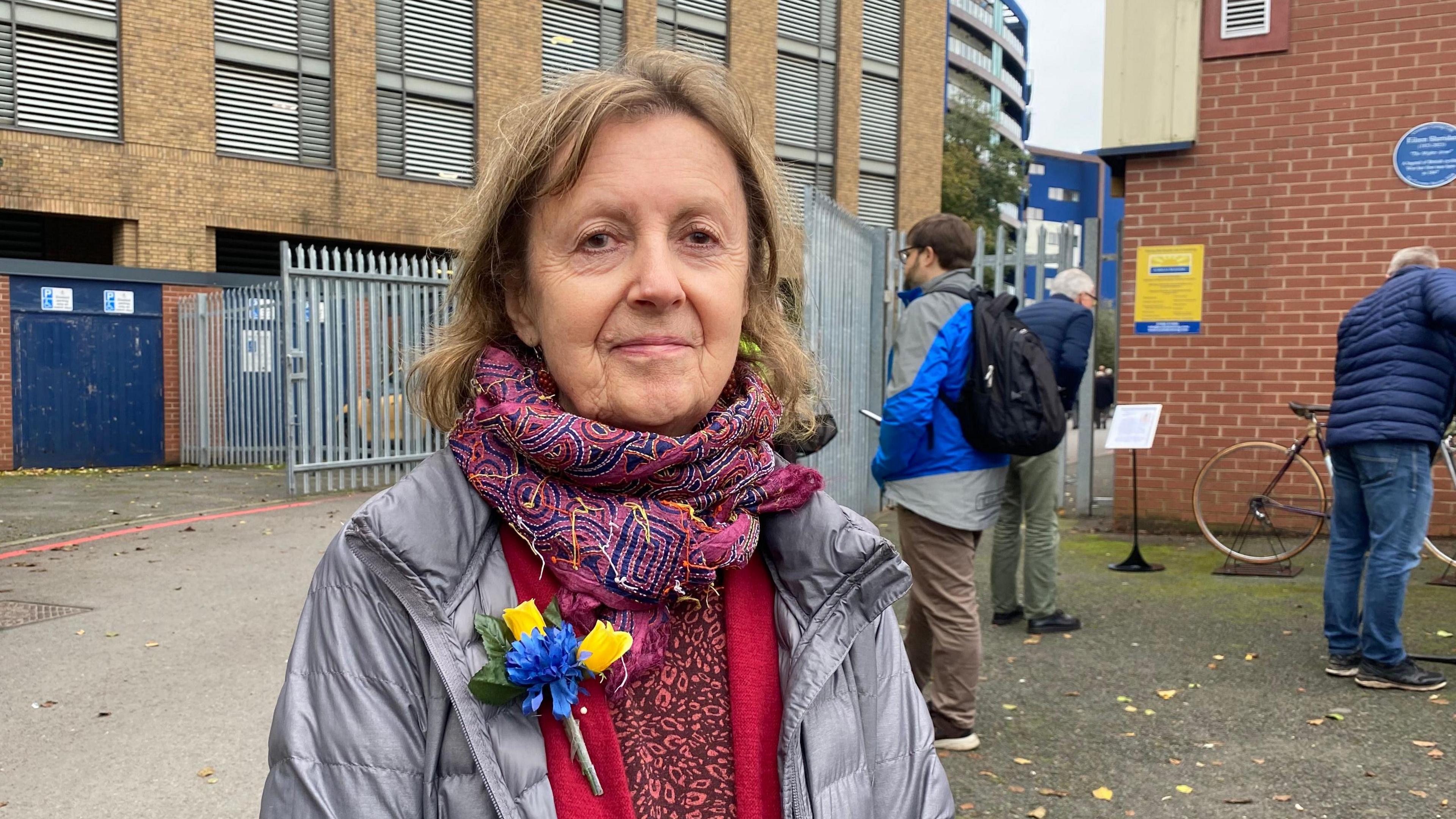 Louise Sheridan wearing a silver puffer coat with a colourful scarf wrapped around her neck