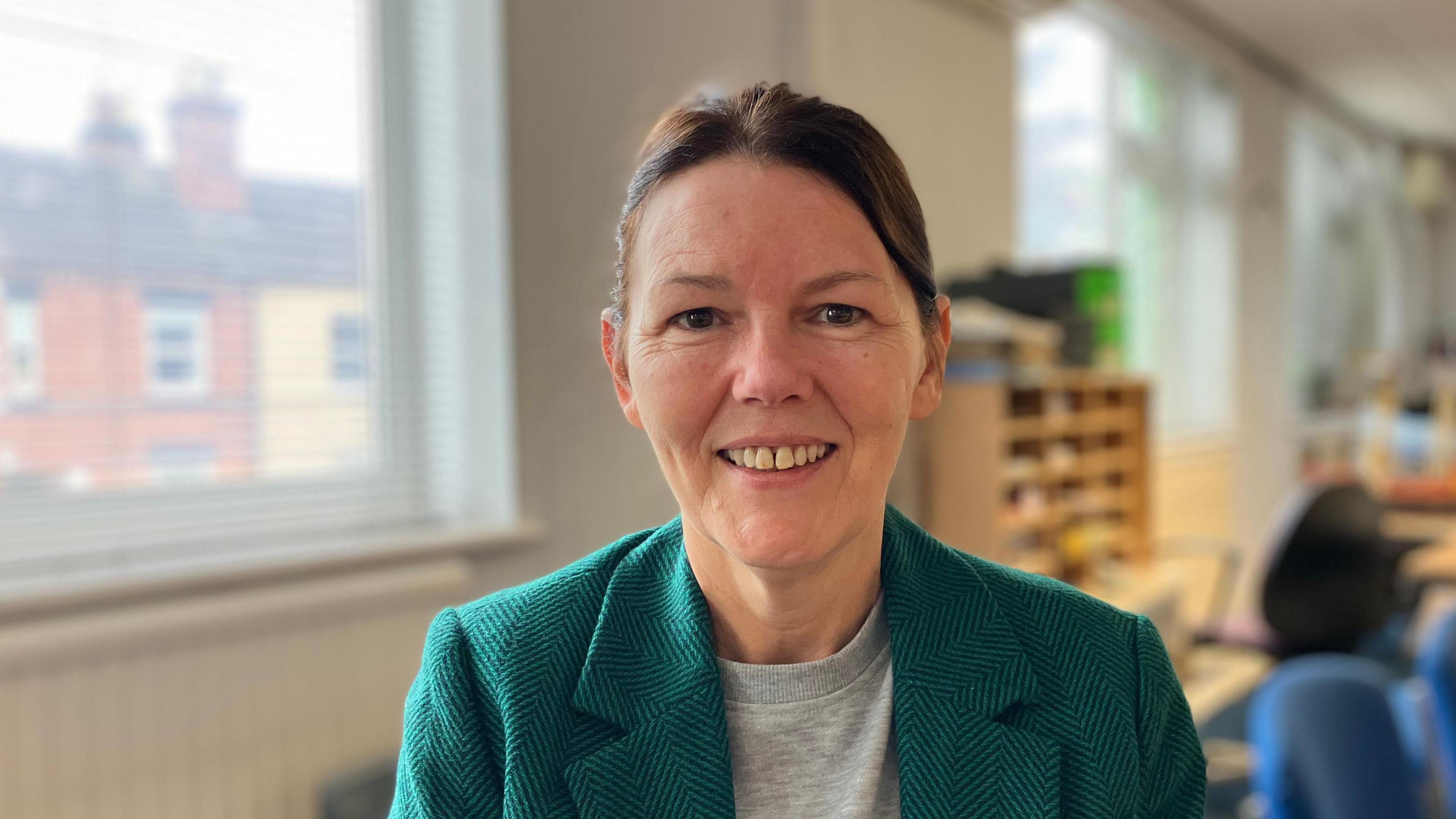 Eileen Jordan, a women in a green coat and grey jumper