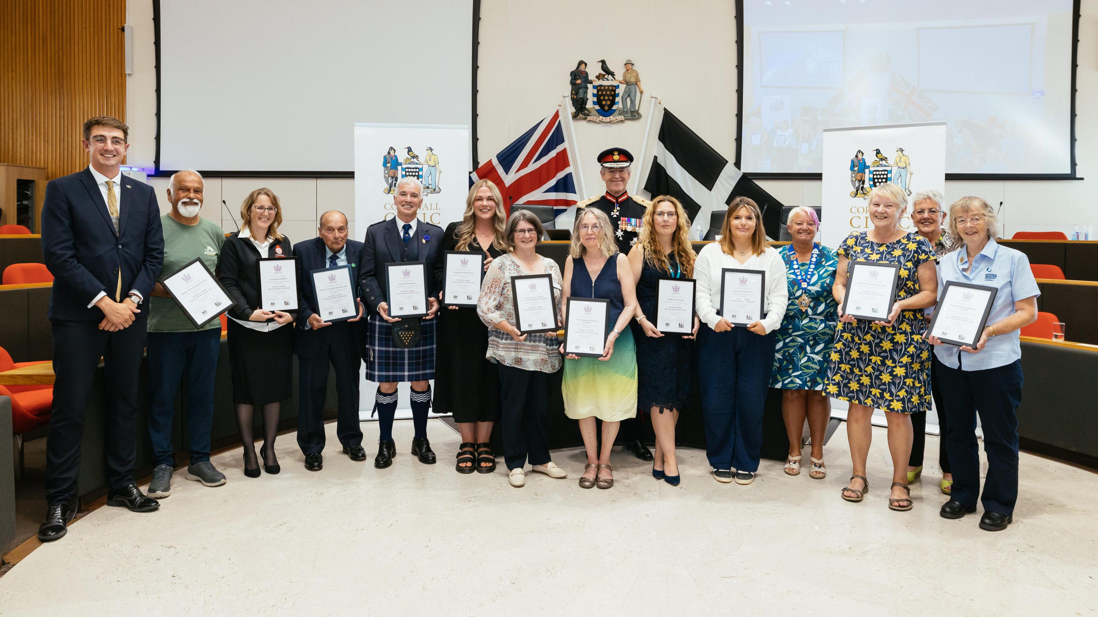 Image shows representatives from the 12 Cornish voluntary groups nominated for a 2024 King’s Award for Voluntary Service, with the Lord Lieutenant of Cornwall, Colonel Sir Edward Bolitho KCVO OBE and Cornwall Council chairman councillor Pauline Giles BEM