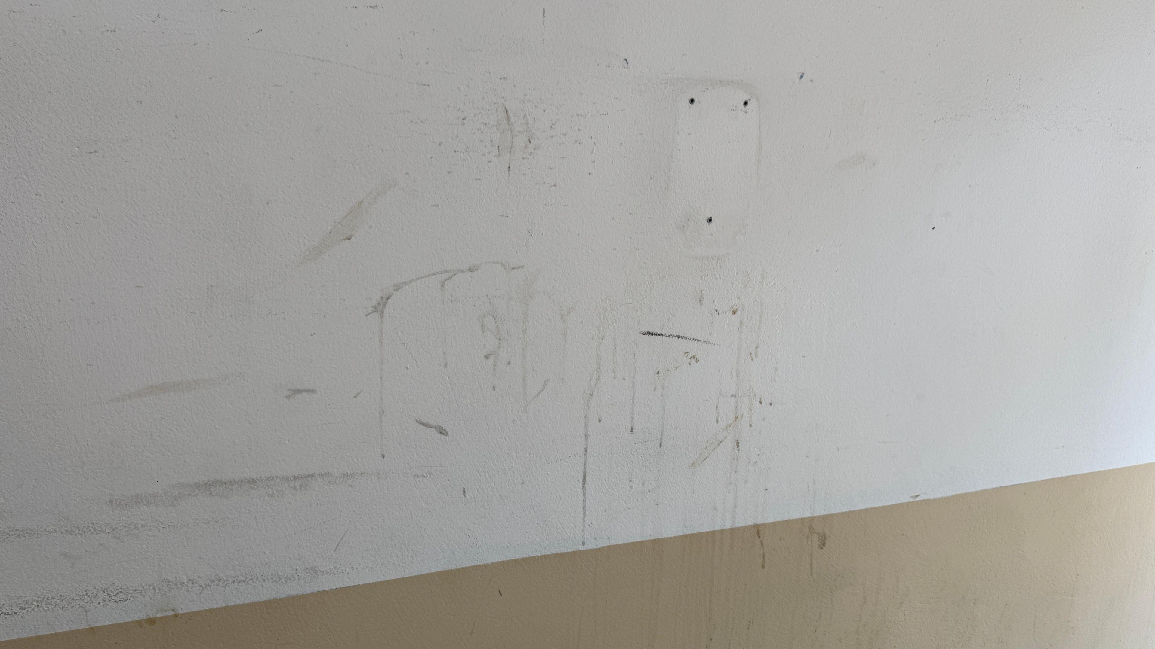 A wall in Smithfield Market with dirt across the wall