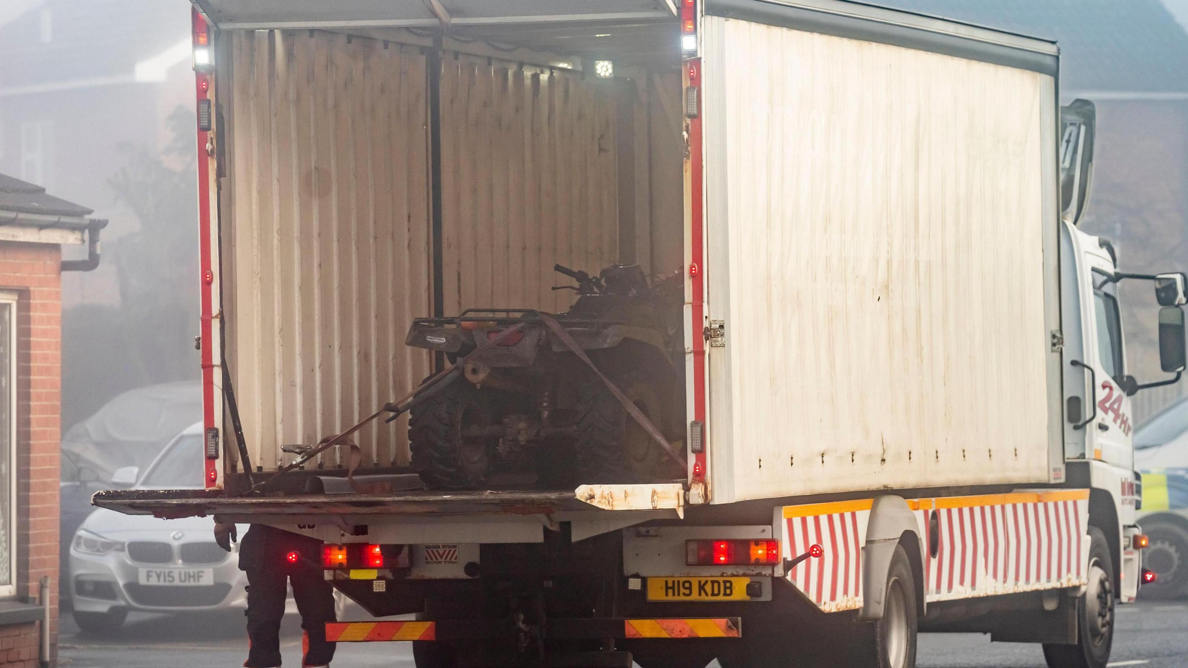 The quad bike in the back of a white lorry.