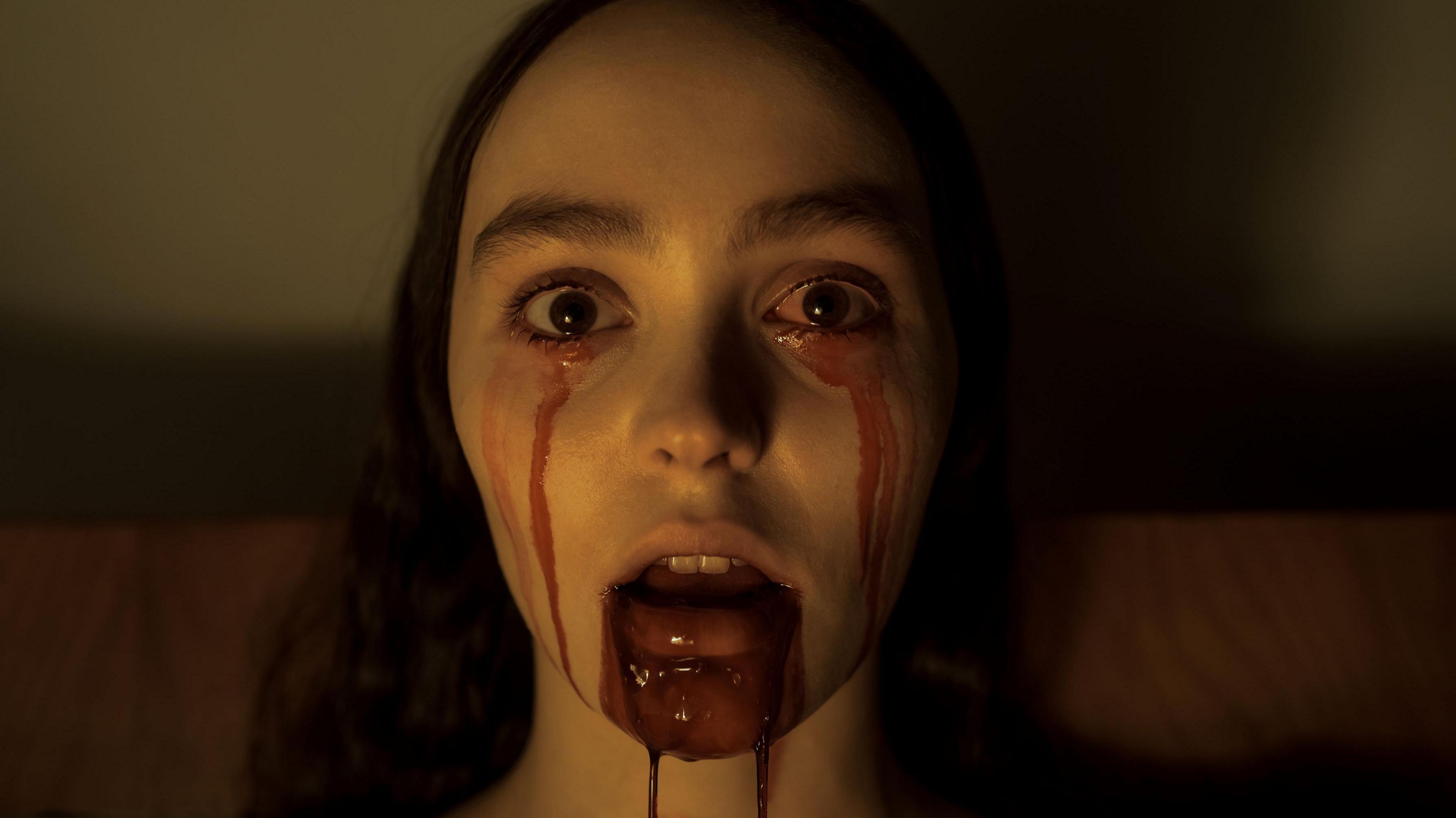 Lily-Rose Depp as Ellen Hutter in Nosferatu with blood seeping out of her mouth and across her face