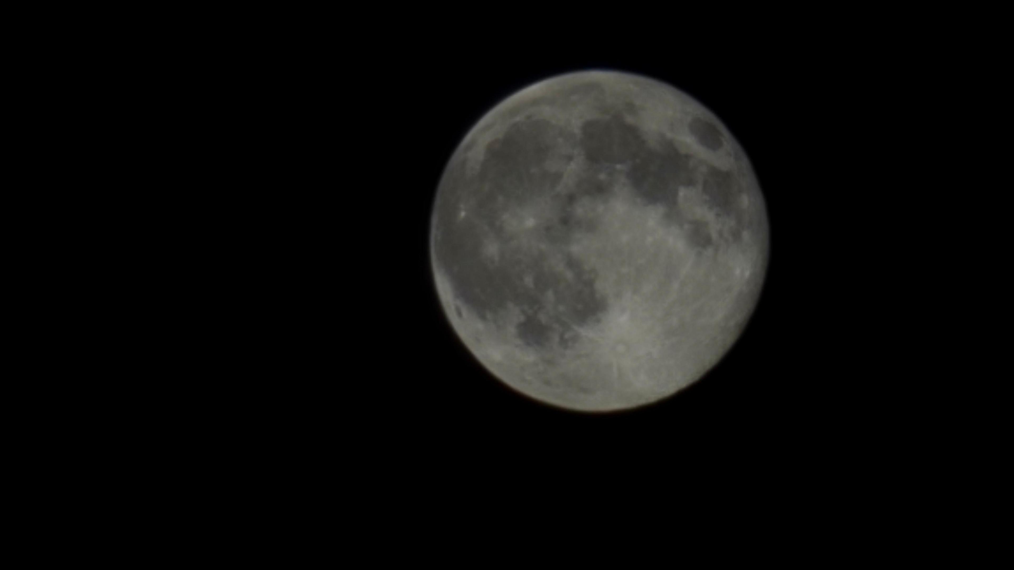 A close up of the moon with craters visible.