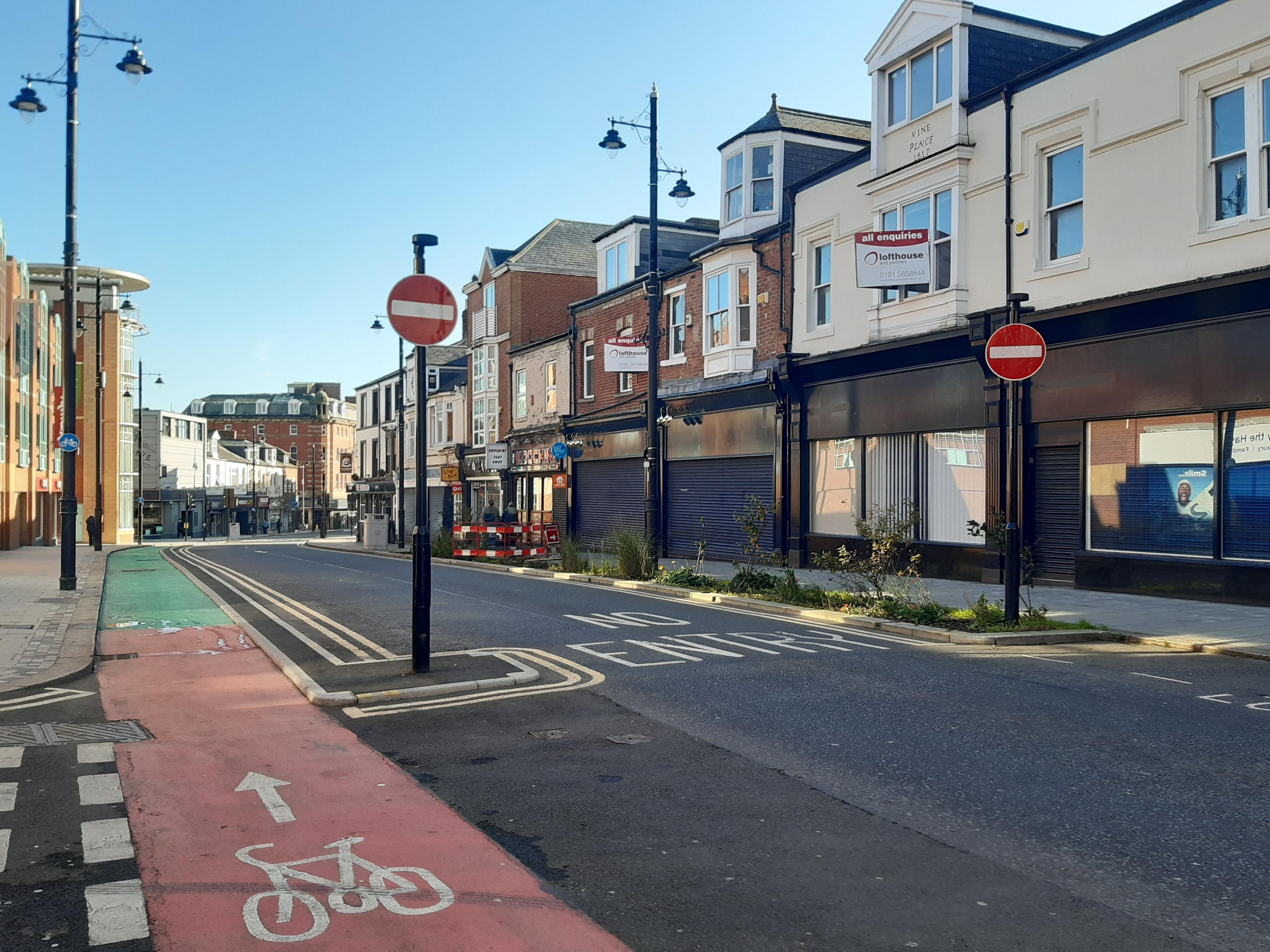 The other side of Holmeside with the words 'no entry' written on the road and two red no entry circular signs on either side.