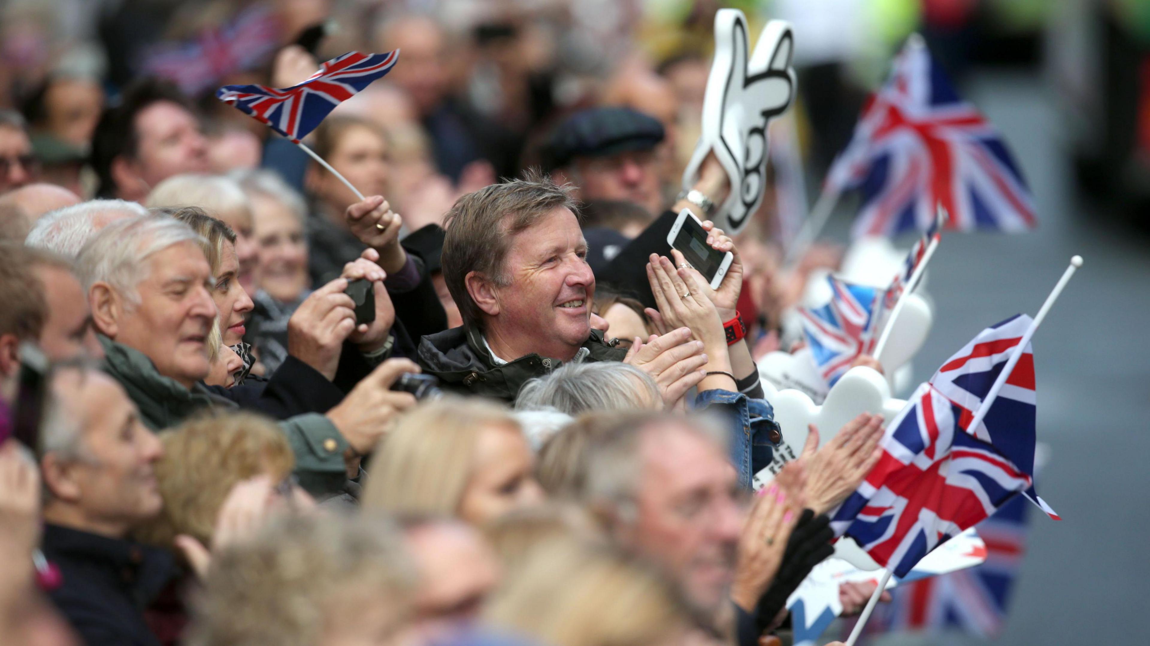 A crowd claps and waves union flags during the victory parade in Manchester following the 2016 Olympics and Paralympics.
