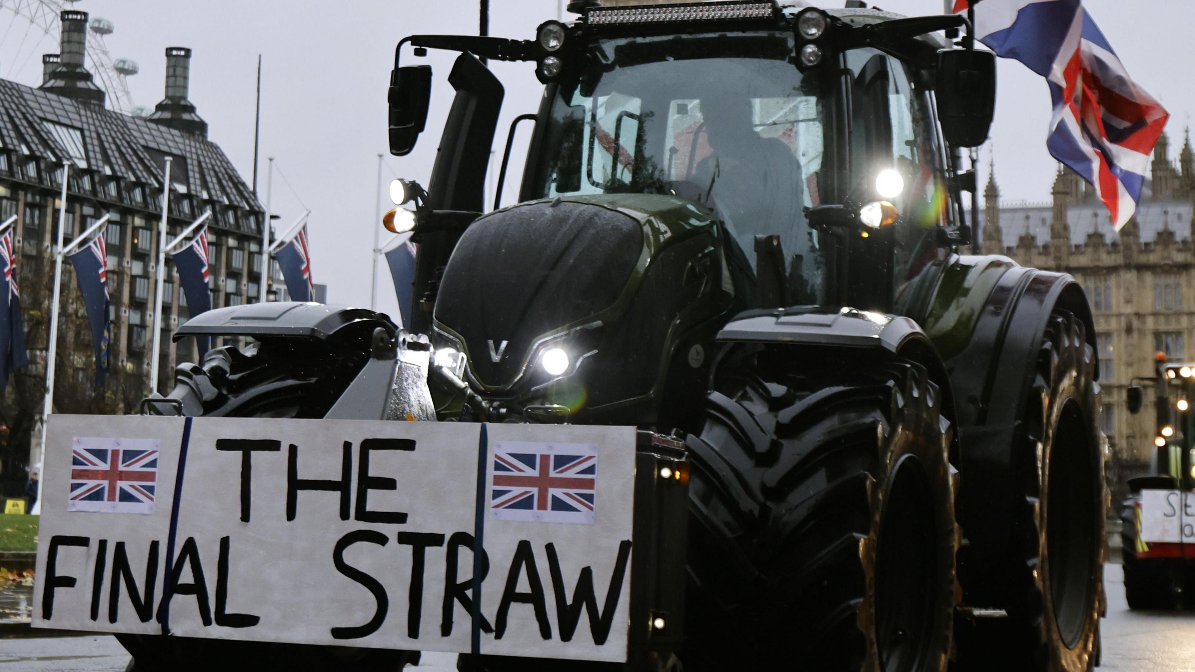 A black  tractor with a sign saying "The Final Straw" is in front of Westminster. 