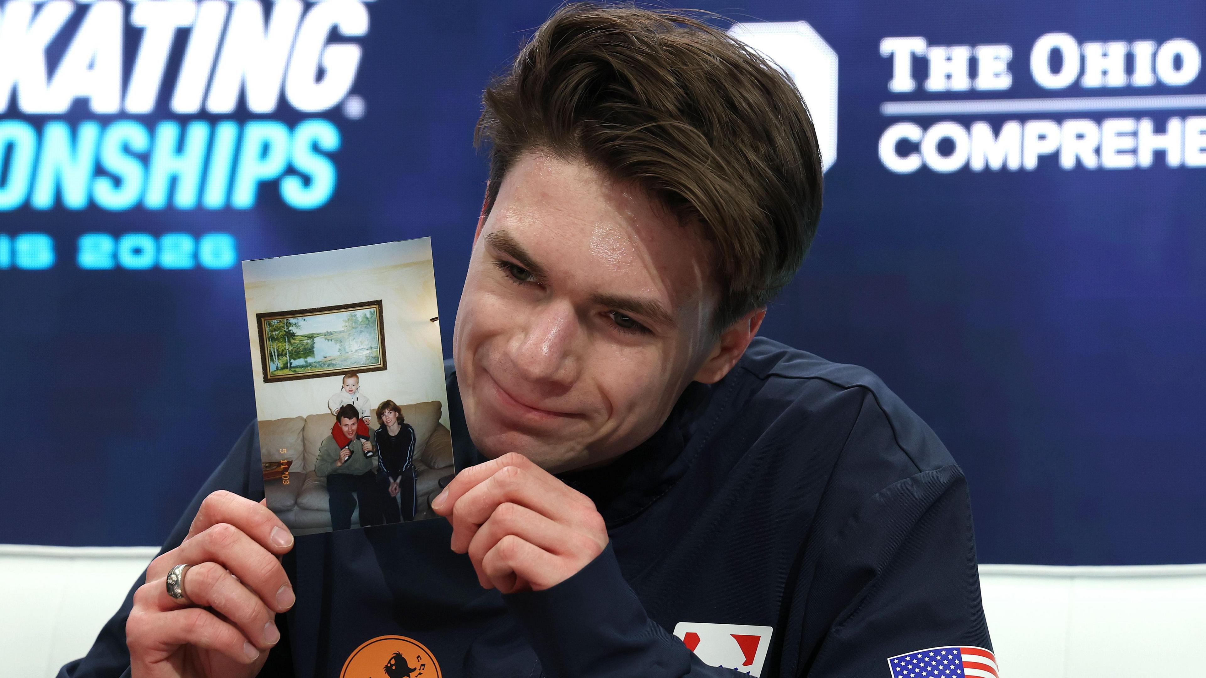 Maxim Naumov holds a photograph of his parents after competing in the Championship Men Free Skating during the 2026 United States Figure Skating Championships