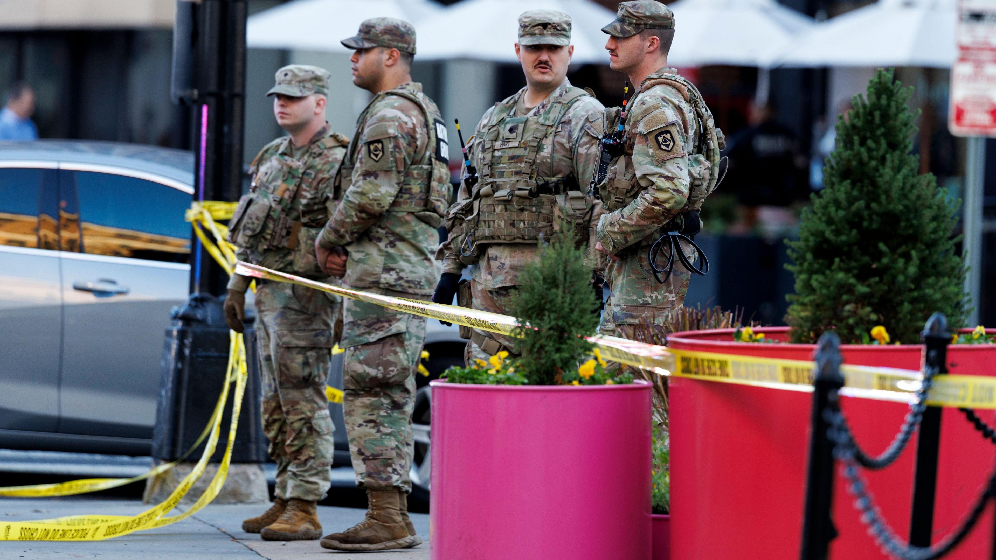 Yellow police tape surrounds four National Guardsmen who are standing close to the scene where two West Virginia National Guard members were shot in Washington, DC, USA
