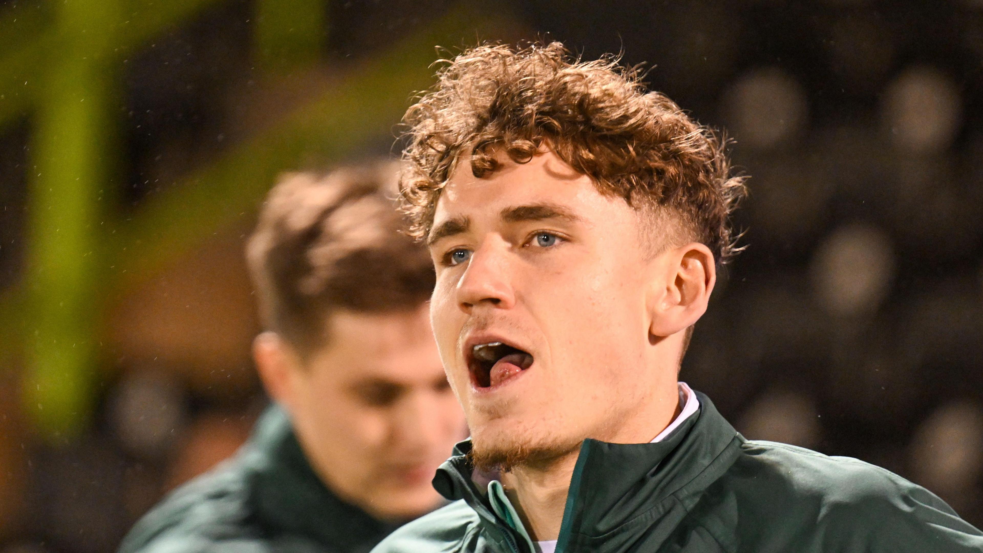 Isaac Moore head shot as he warms up bevfore a game in green Forest Green Rovers tracksuit