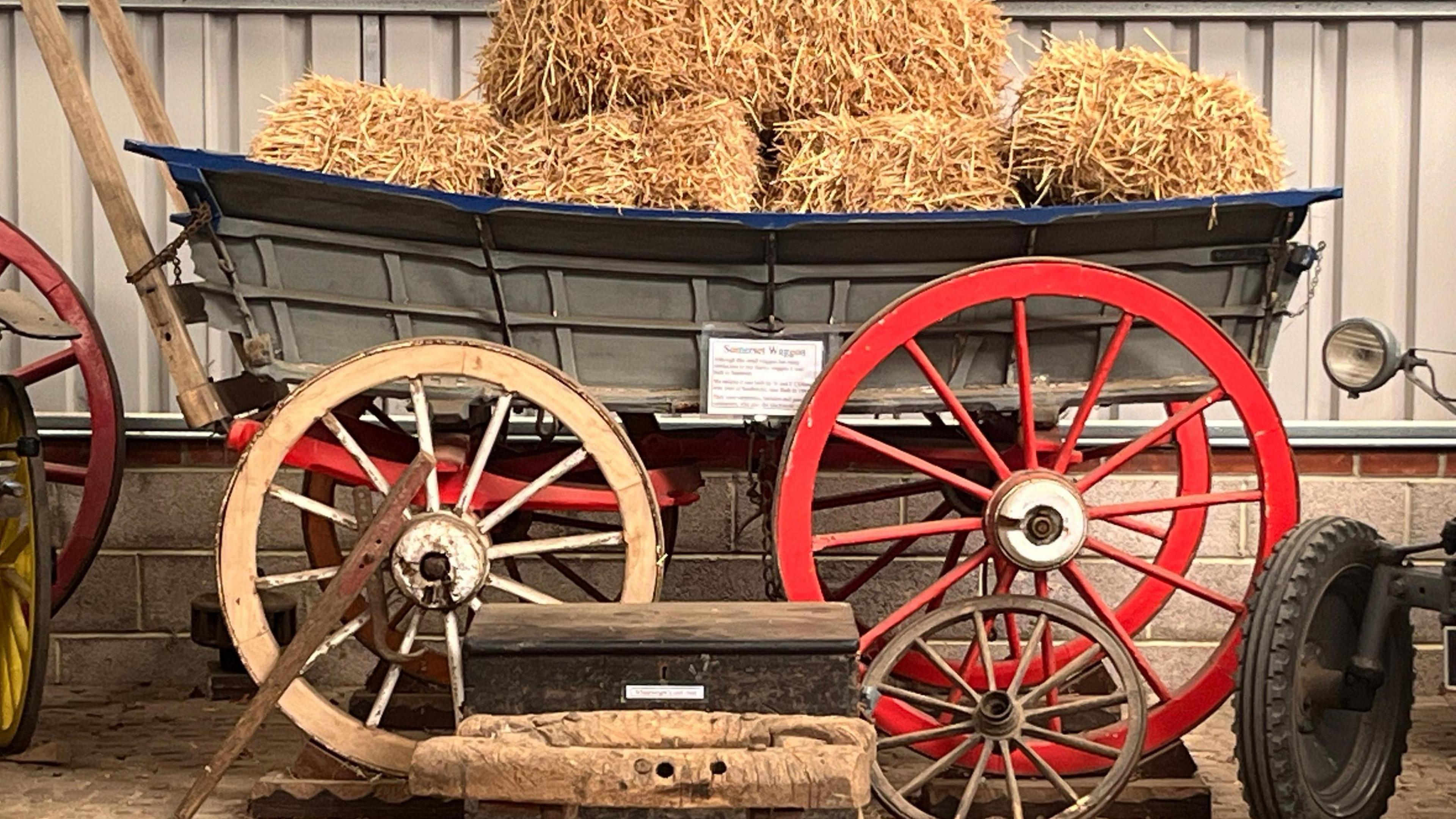 A hay cart piled high with bales of hay is an exhibit in the museum