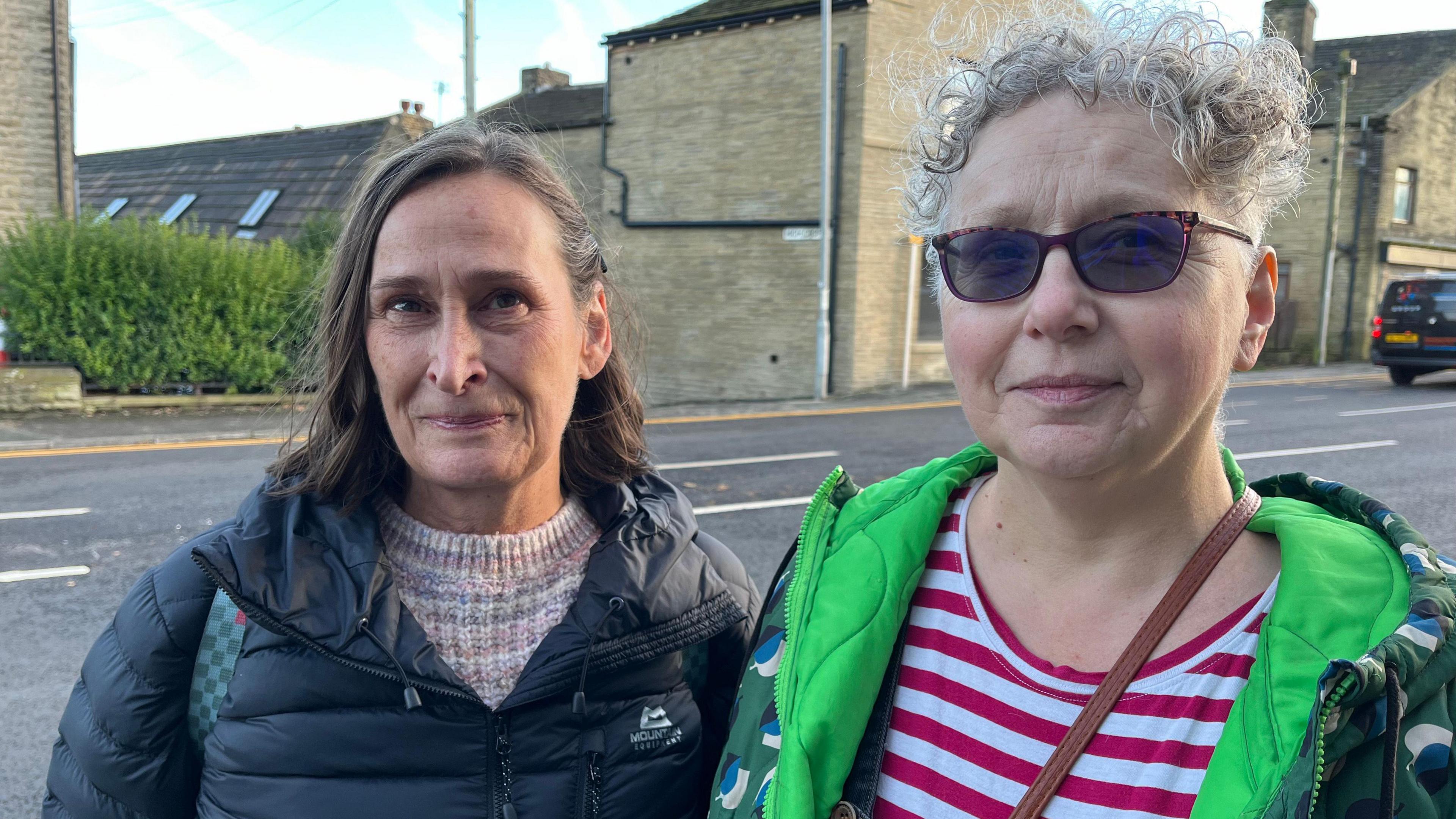 Two women looking at the camera with plain faces