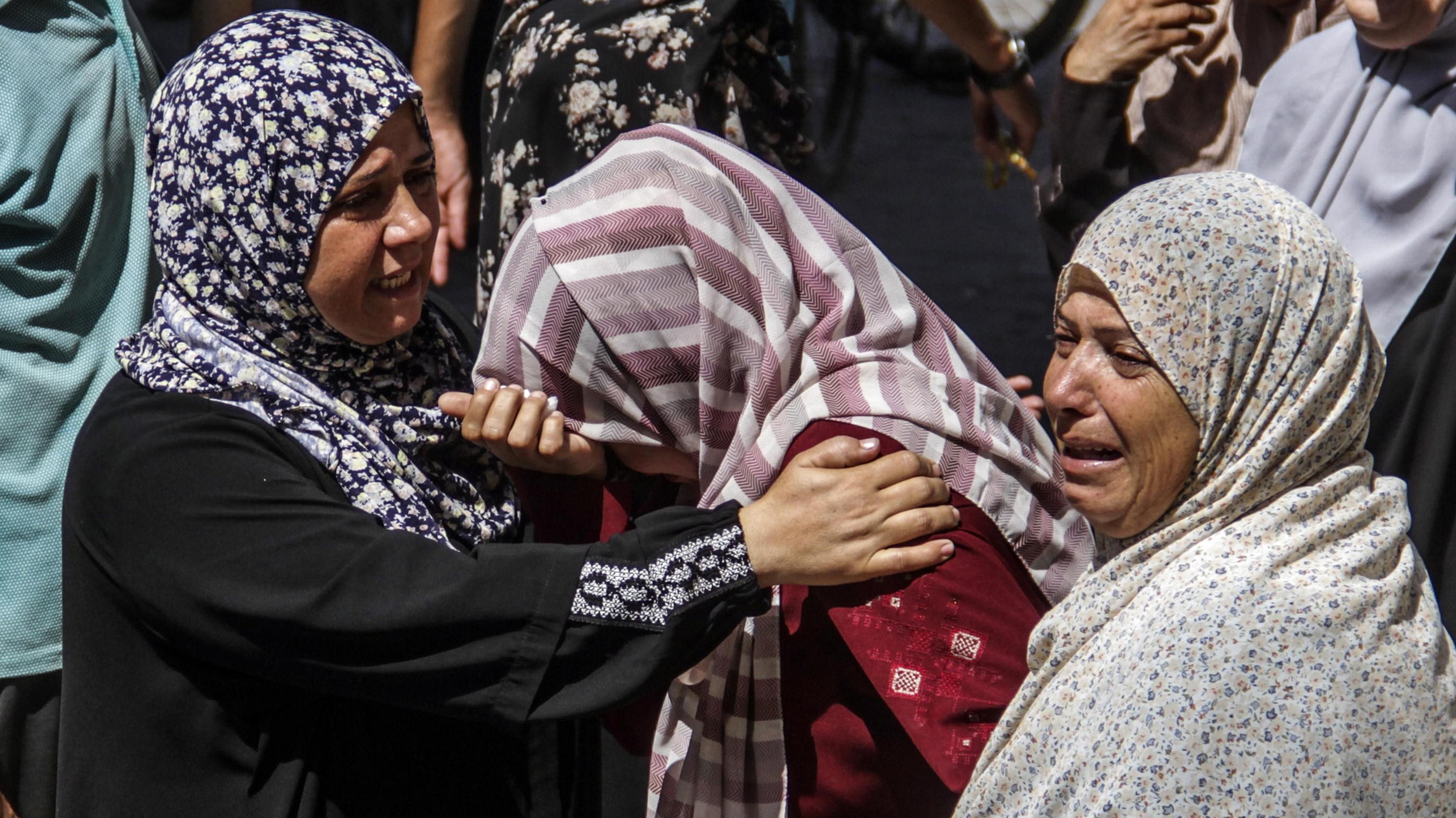 Women mourn those killed in the strike on a school sheltering displaced people