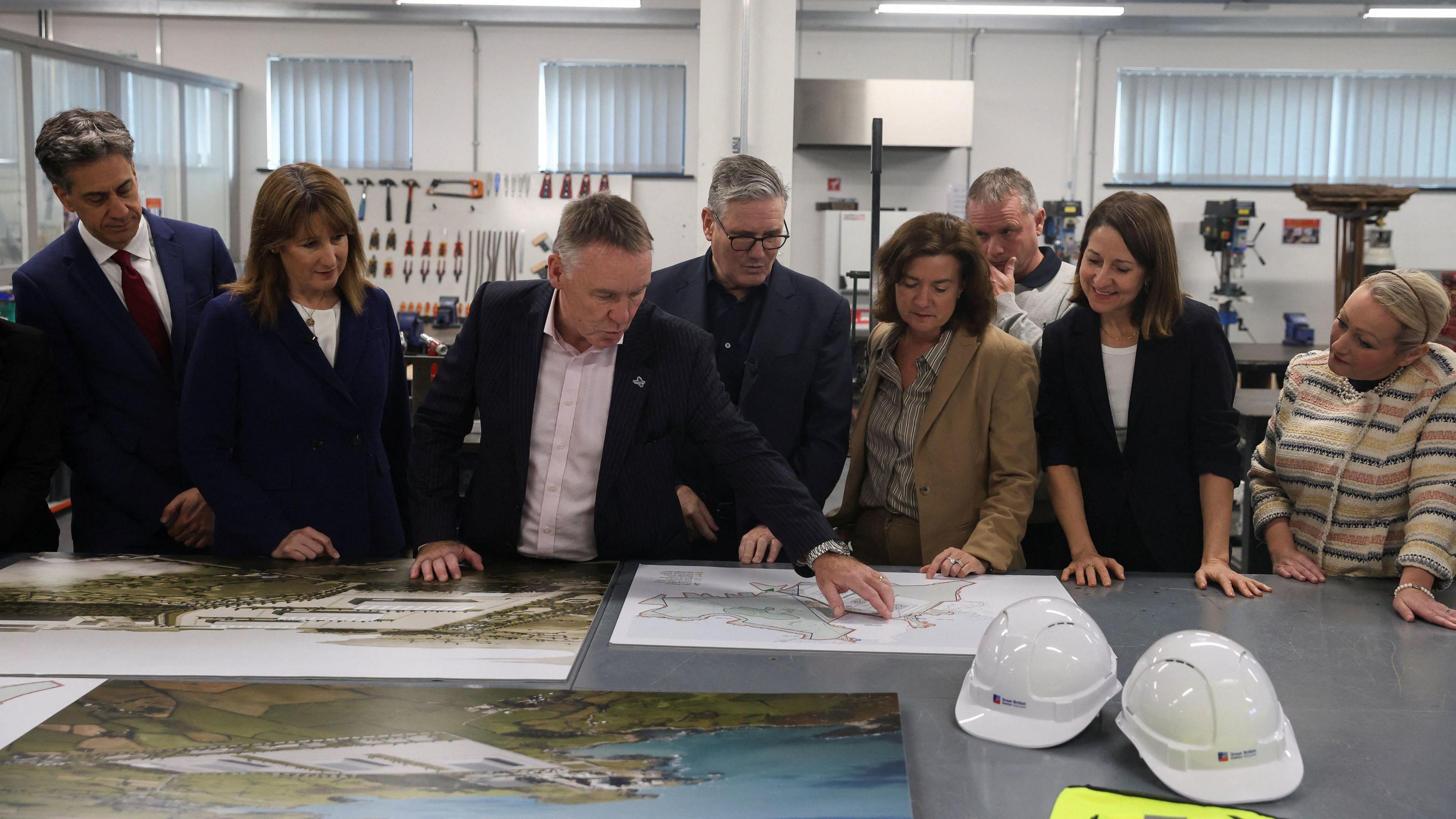 Energy Secretary Ed Milliband, Chancellor of the Exchequer Rachel Reeves, Simon Bowen, Interim Chair for Great British Energy - Nuclear (GBE-N), Prime Minister Sir Keir Starmer, First Minister of Wales Eluned Morgan and Science and Technology Secretary Liz Kendall look at maps of the Wylfa plant during a visit to an engineering workshop at Coleg Menai in Anglesey. The UK's first small modular reactor (SMR) nuclear power station will be built at Wylfa in North Wales by publicly owned Great British Energy-Nuclear and is backed by £2.5 billion investment from the Government.