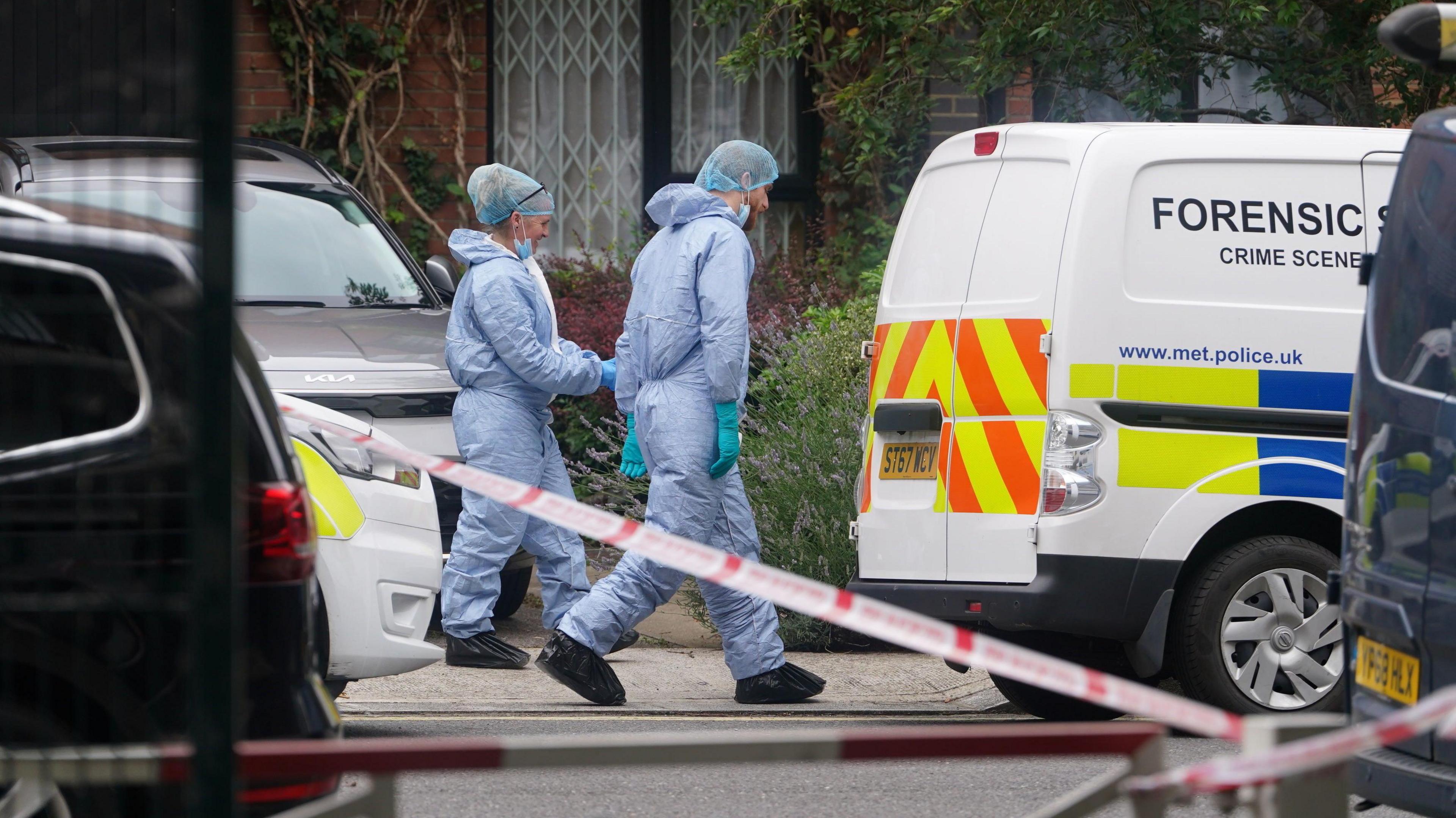 Forensic officers and a police van at an address in Shepherd's Bush