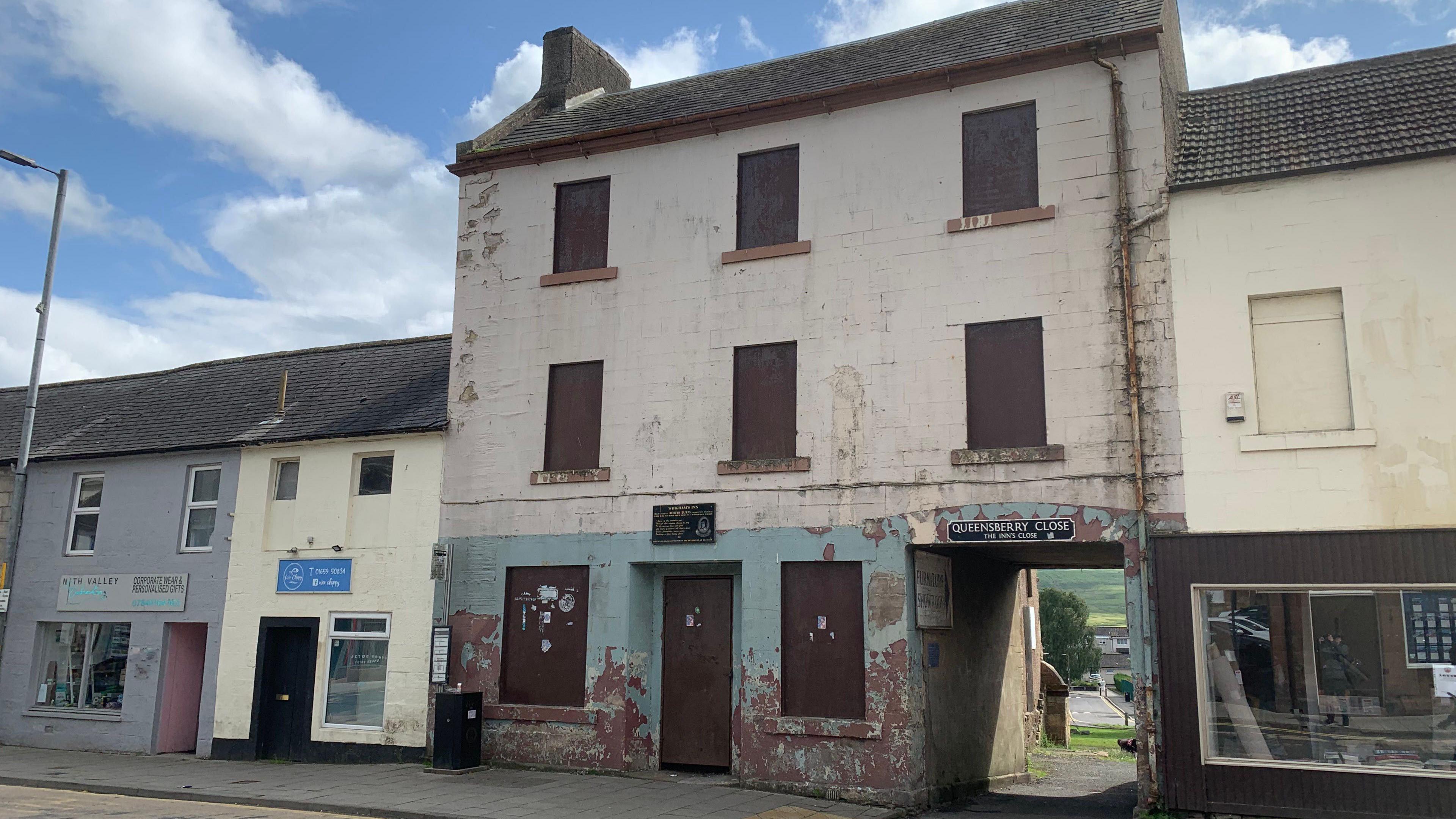 A run down former pub in the south of Scotland town of Sanquhar over three storeys with paint peeling from its front