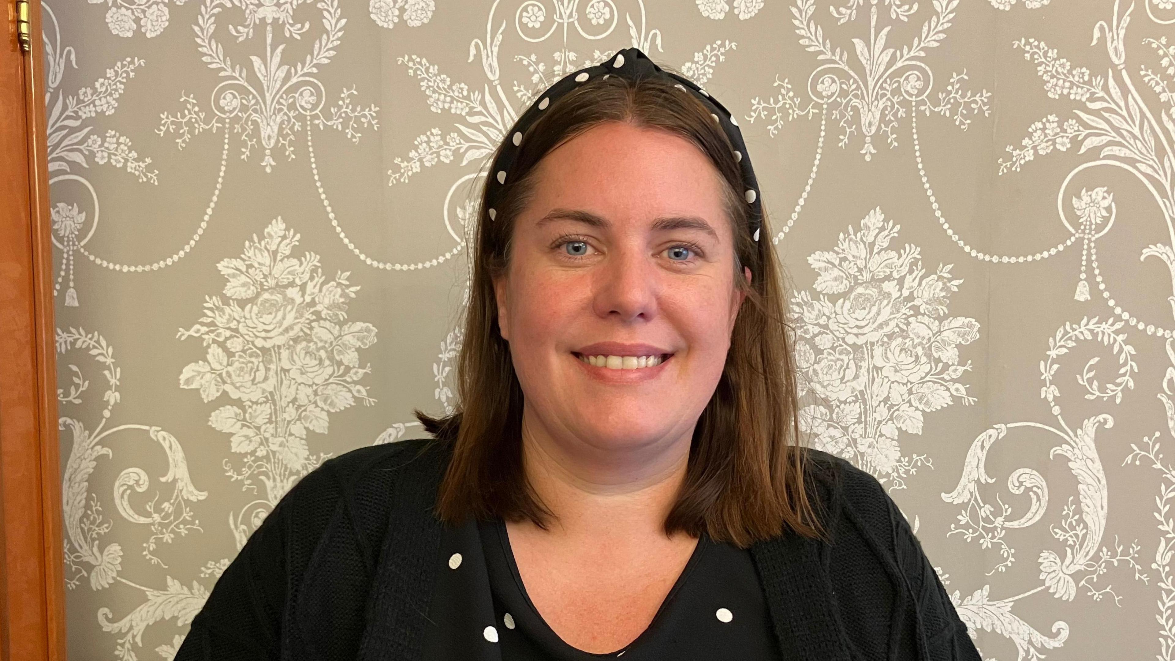 Hayley Foster wearing a black headband with white polka dots and a black top