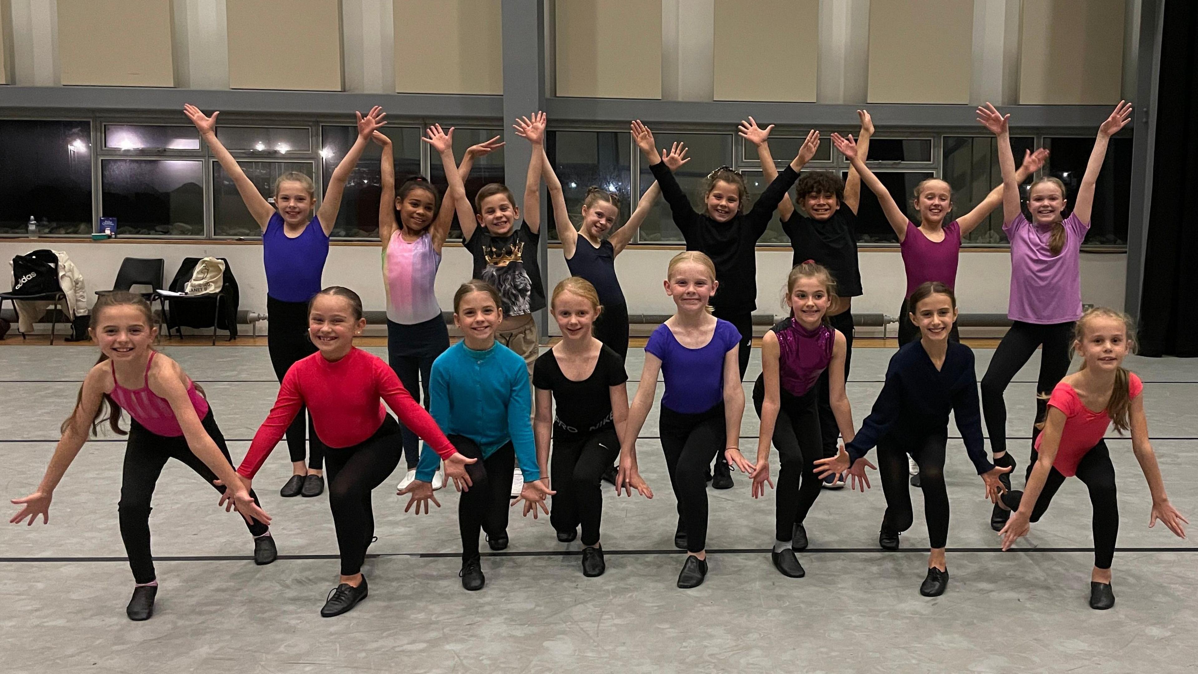 The sixteen children from the ensemble pose for the camera. 