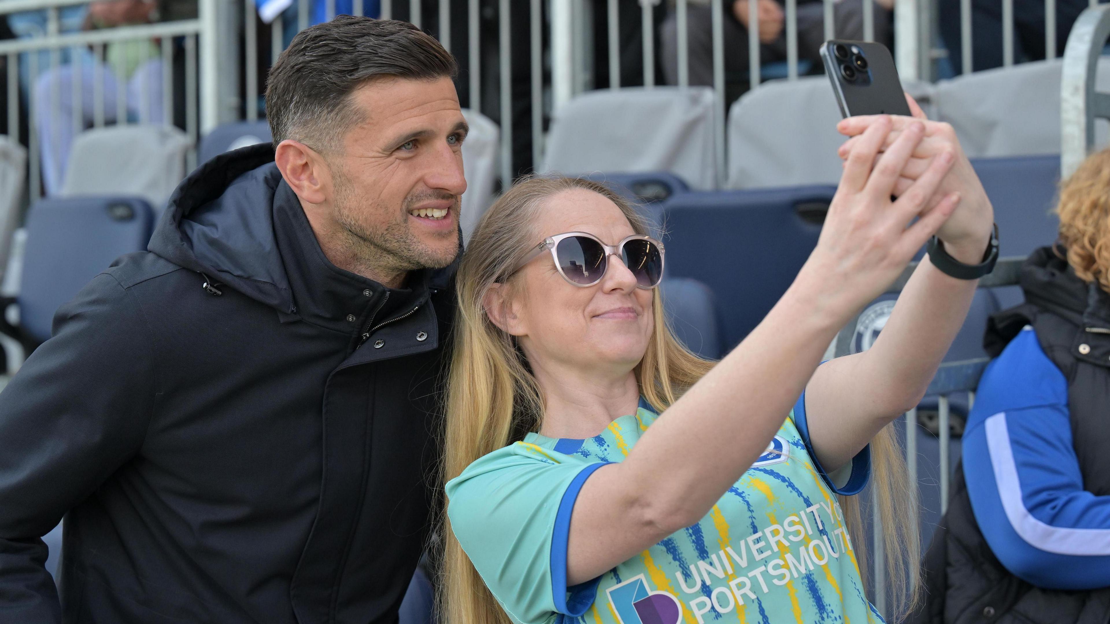 A smiling John Mousinho poses for a selfie with a Portsmouth fan before the 1-1 draw with Birmingham