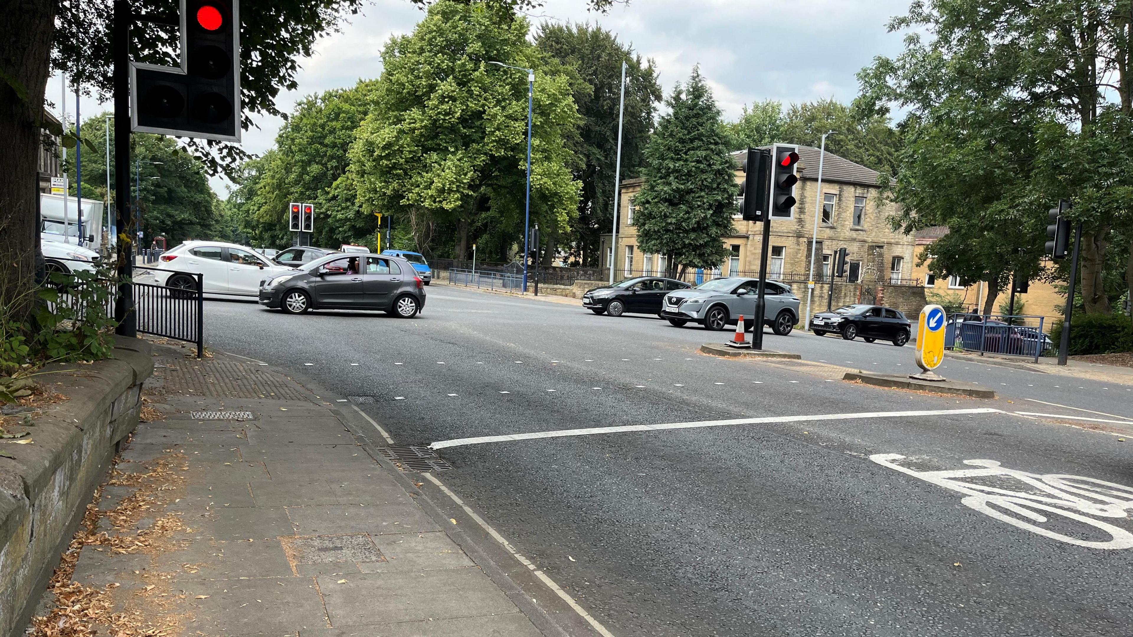 Cars driving on Queens Road where it meets with Manningham Lane