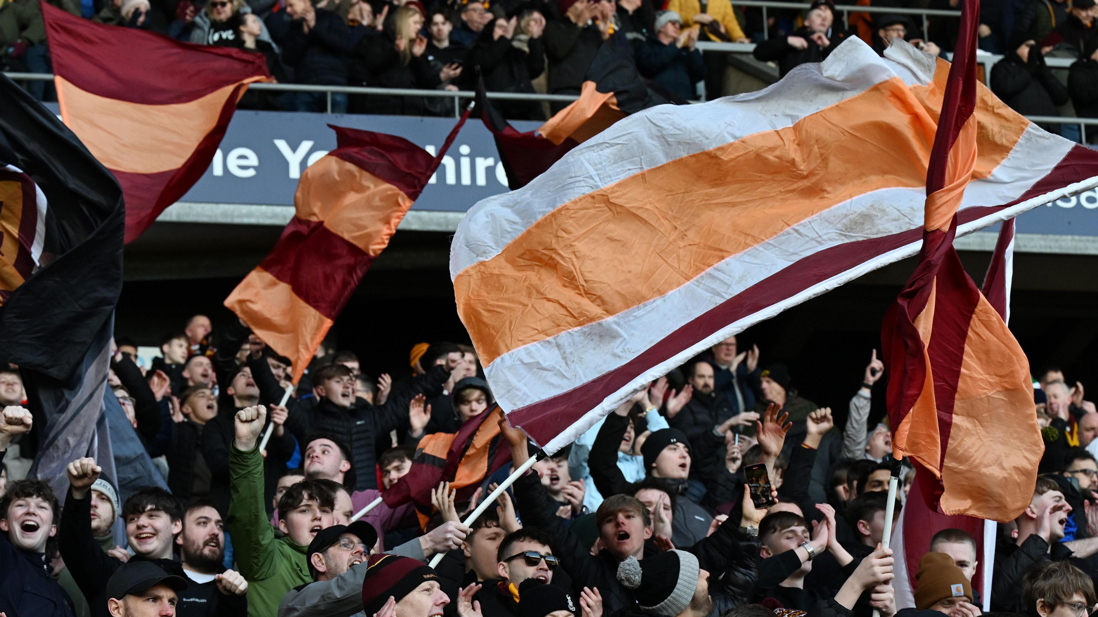 Bradford City supporters waving flags.