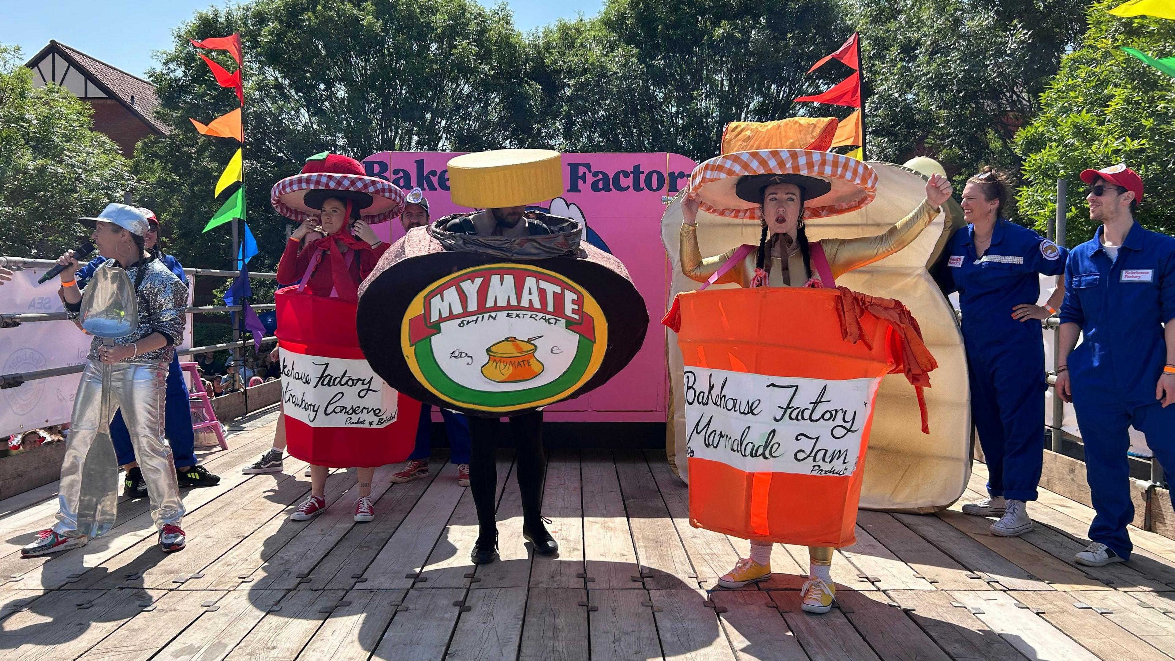 One person in a costume resembling a jar of yeast extract and two more resembling jam