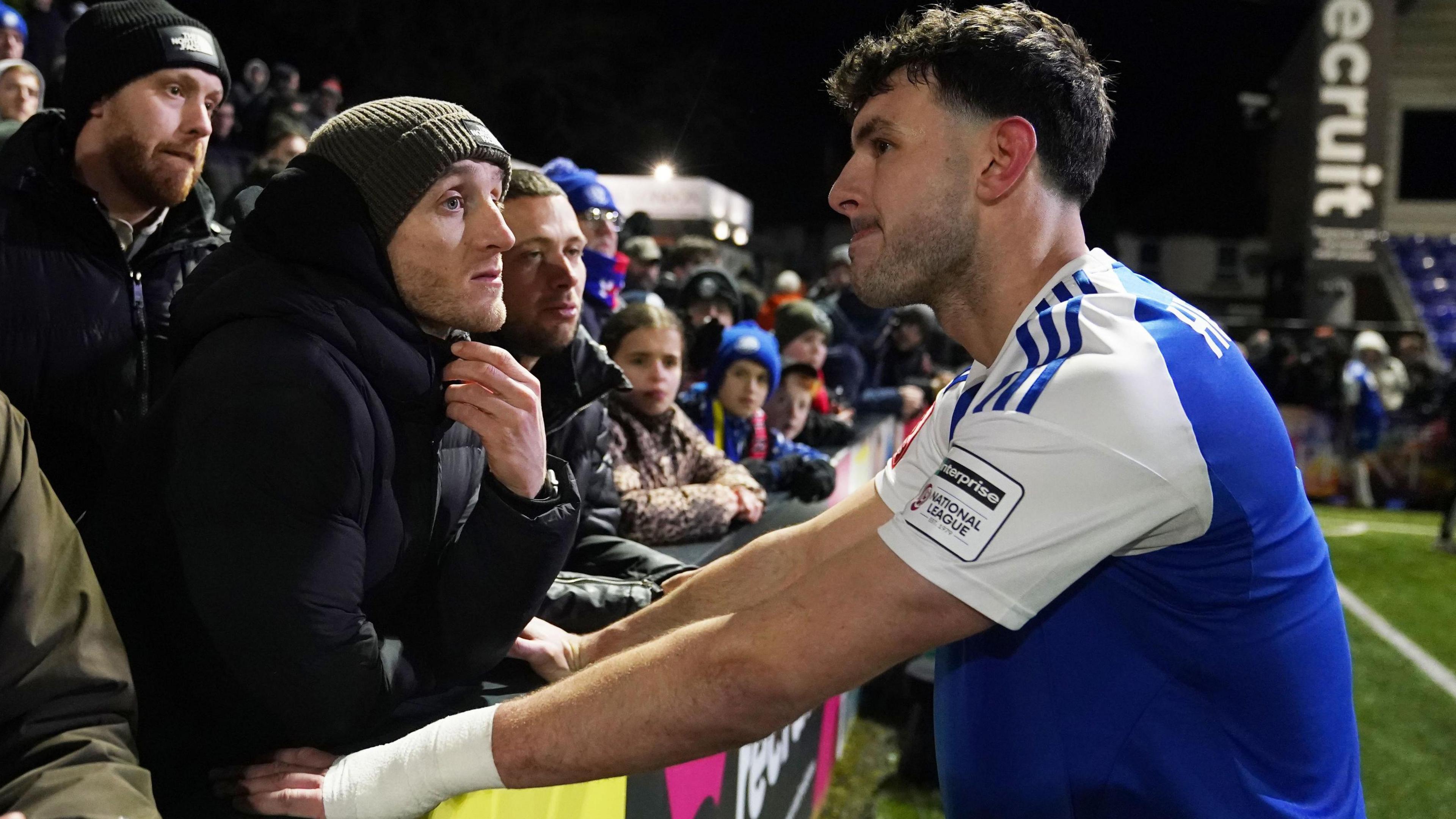 Macclesfield's Sam Heathcote is consoled by fans after his own goal settled the FA Cup fourth round tie against Brentford.