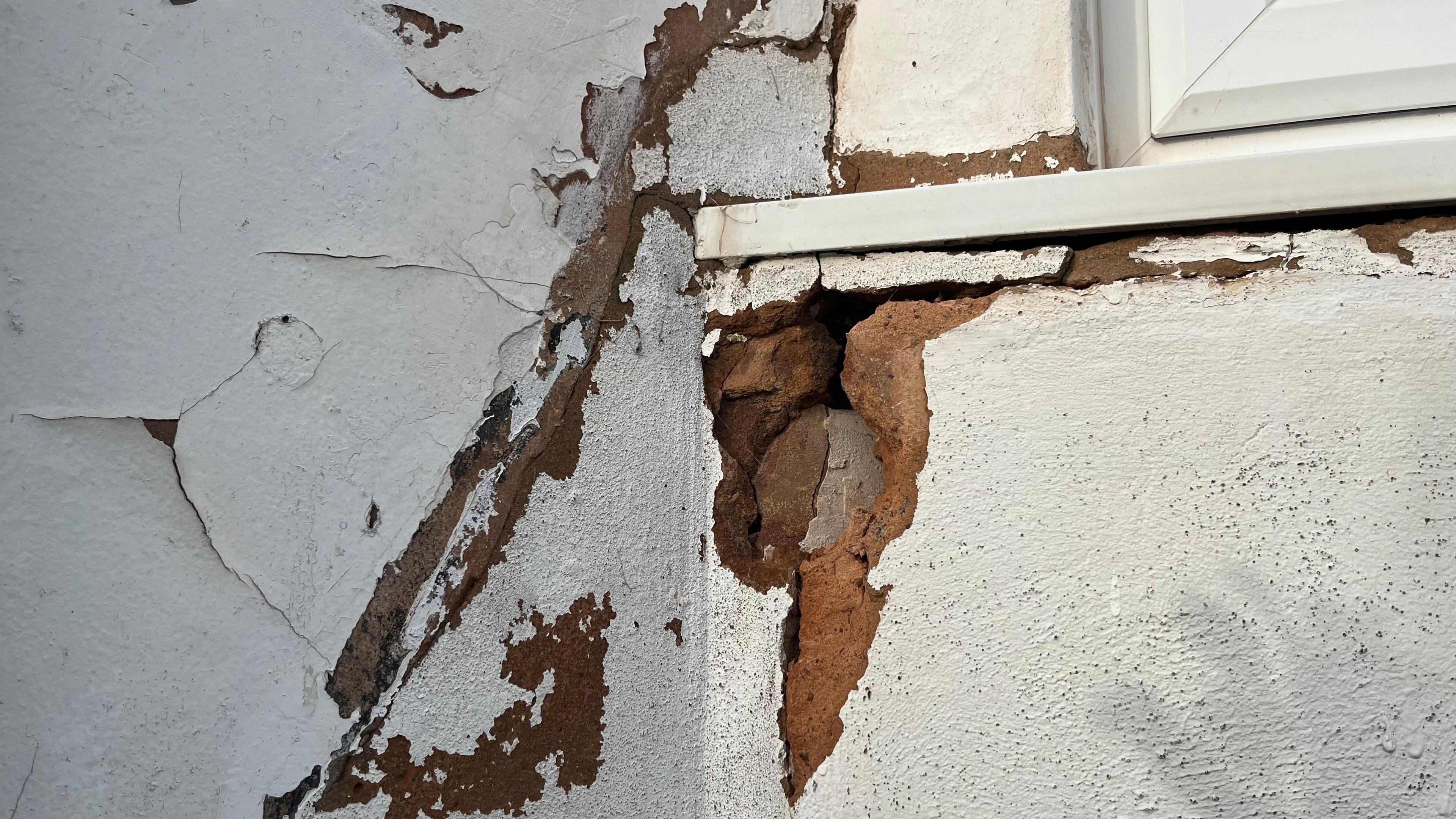 Brickwork crumbling under a bay window