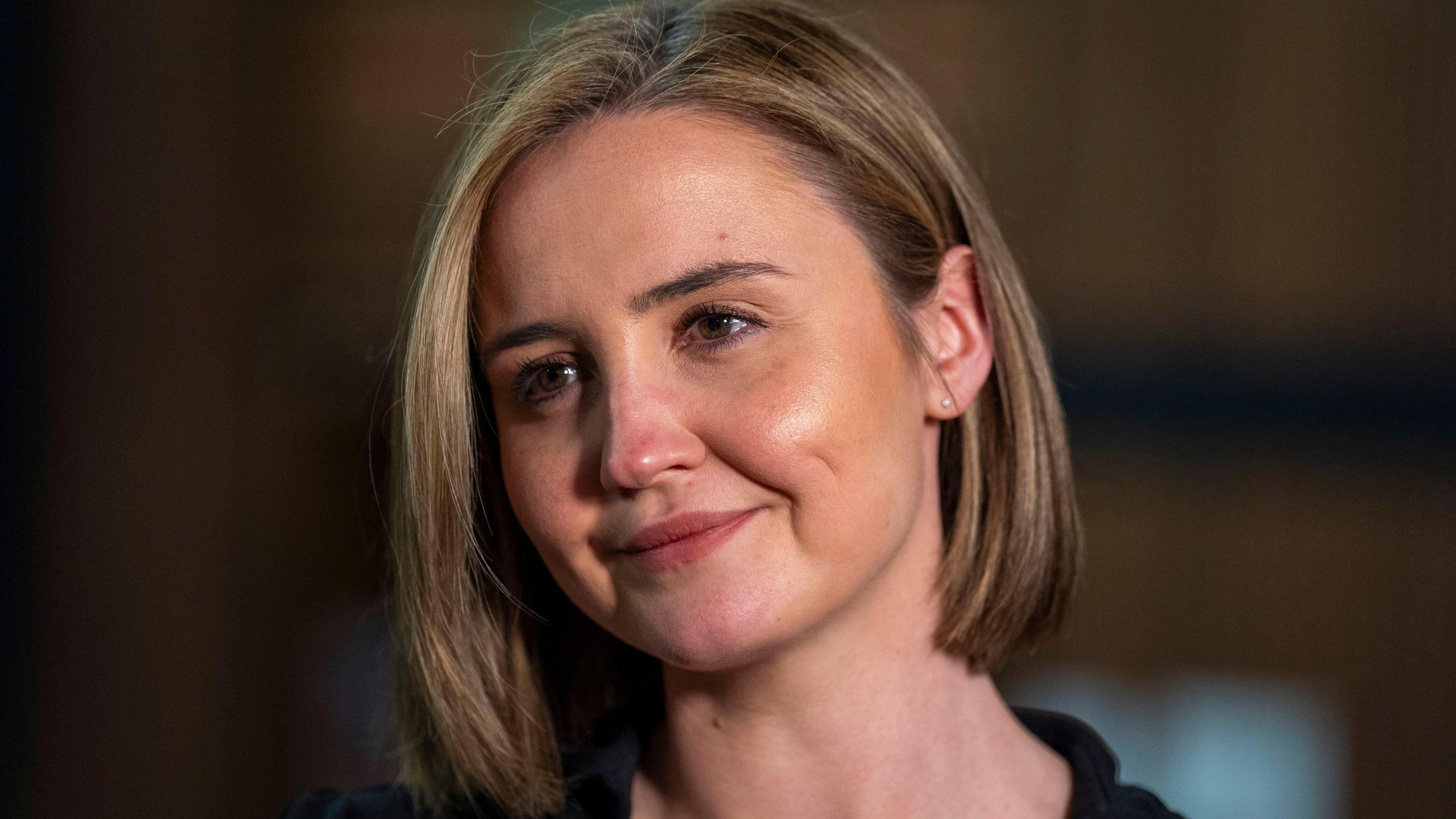 Head shot of a smiling woman with blonde bobbed hair