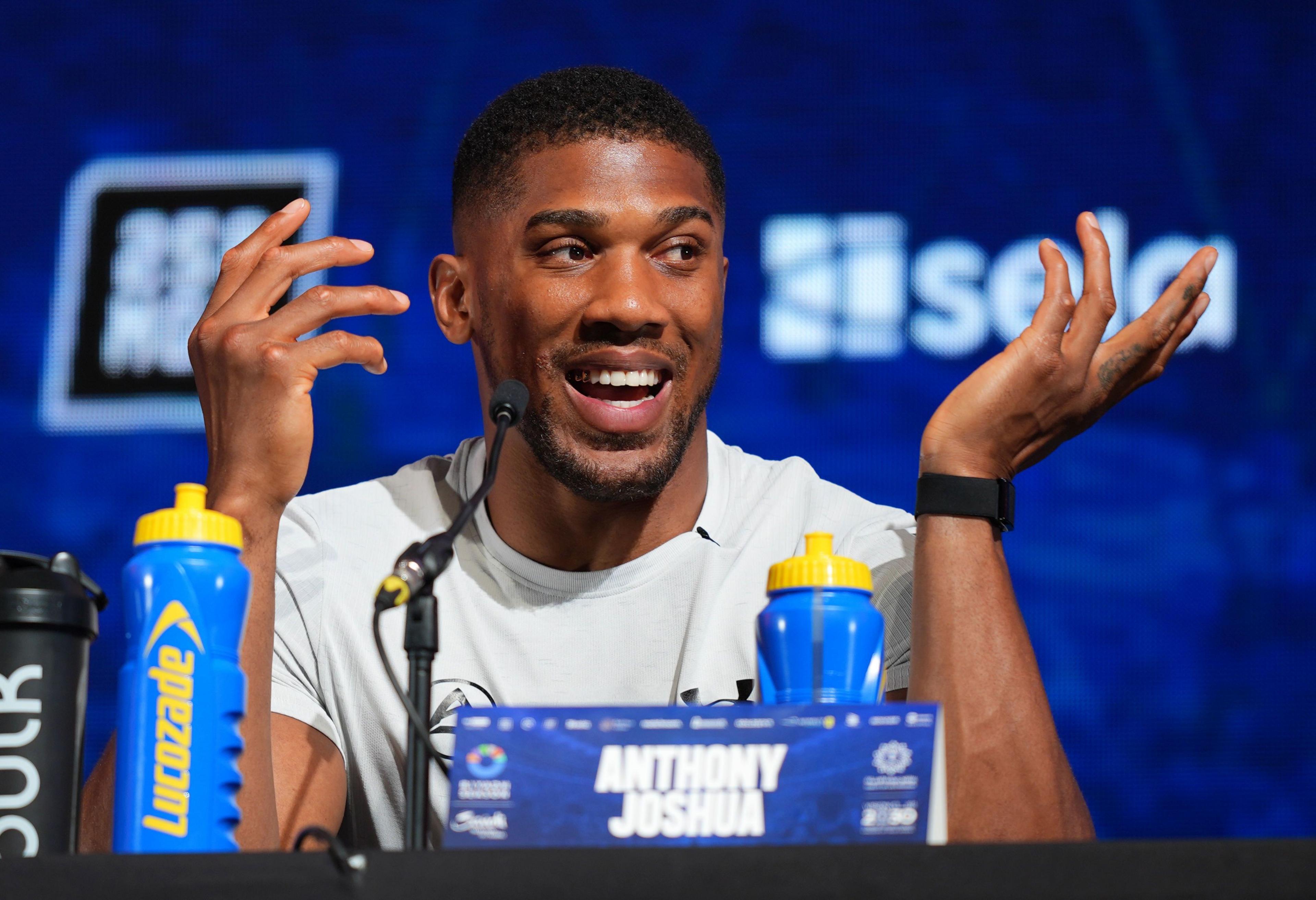 Anthony Joshua laughs during a news conference