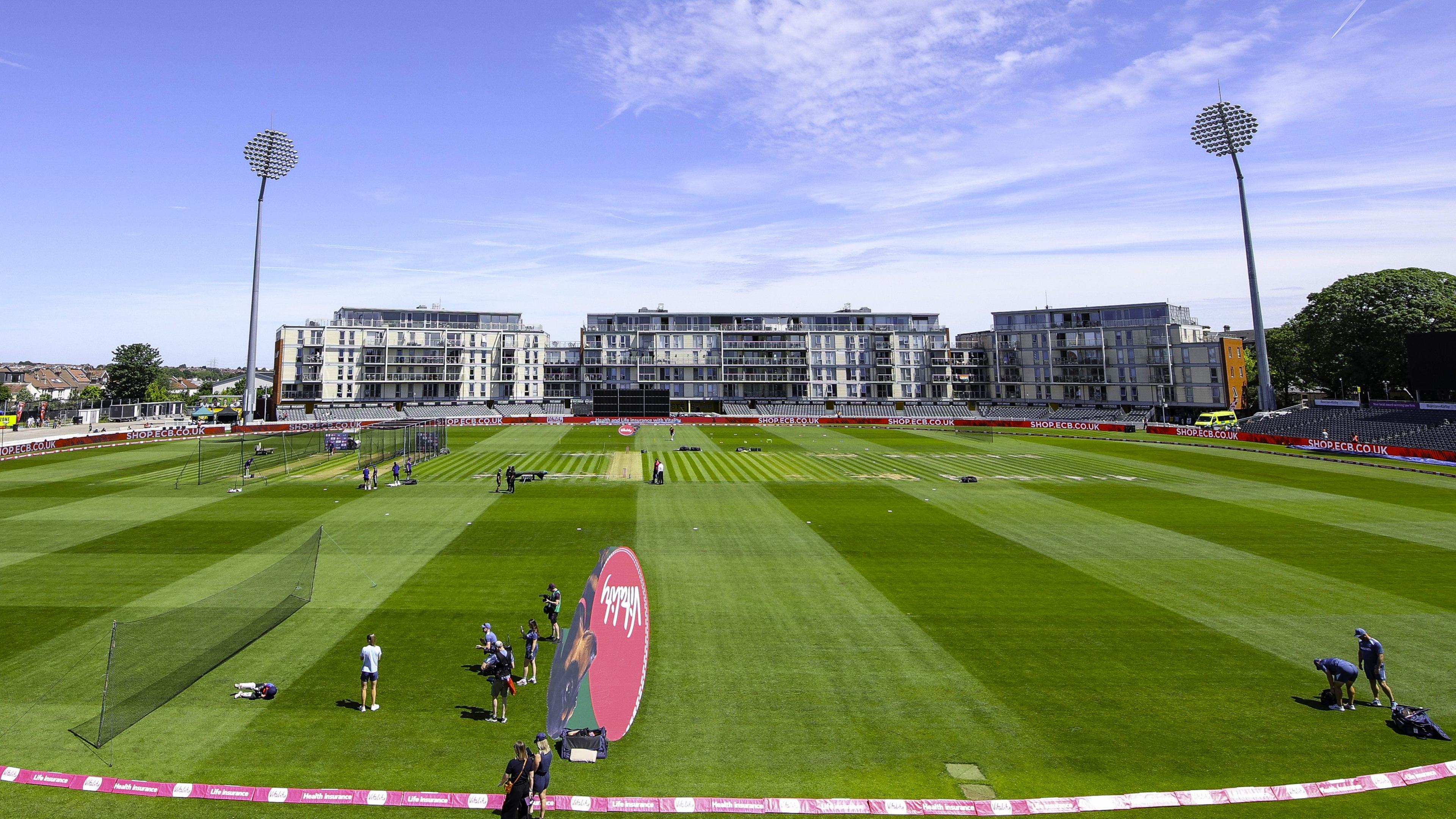 A wide shot of the Seat Unique cricket stadium in Bristol, with flats and high-rise buildings in the background, as a training session takes place on the pitch