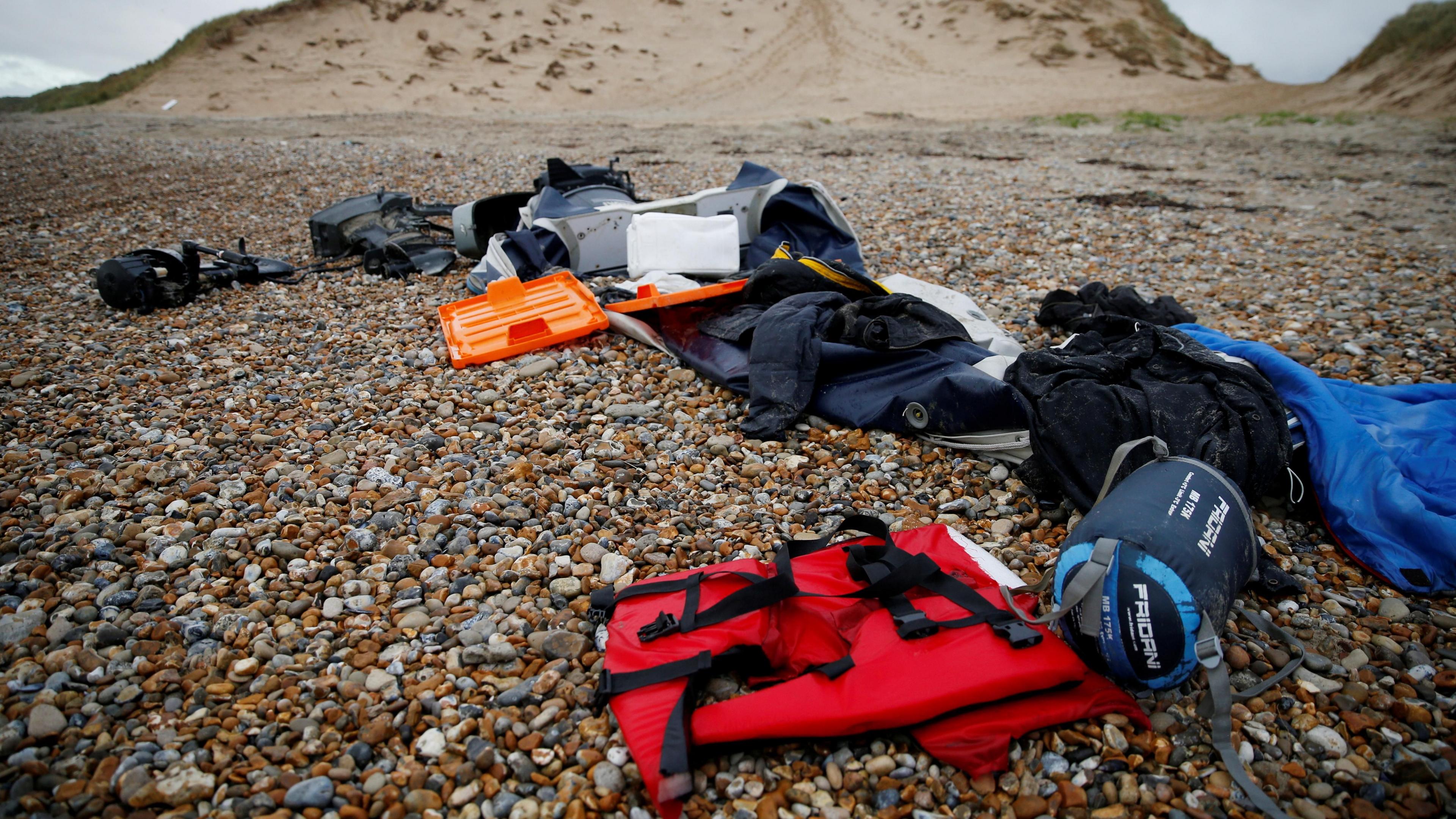 A red life jacket, bags, and other belongings left abandoned on a stony beach, following the death of at least 30 migrants on the English channel in November 2021