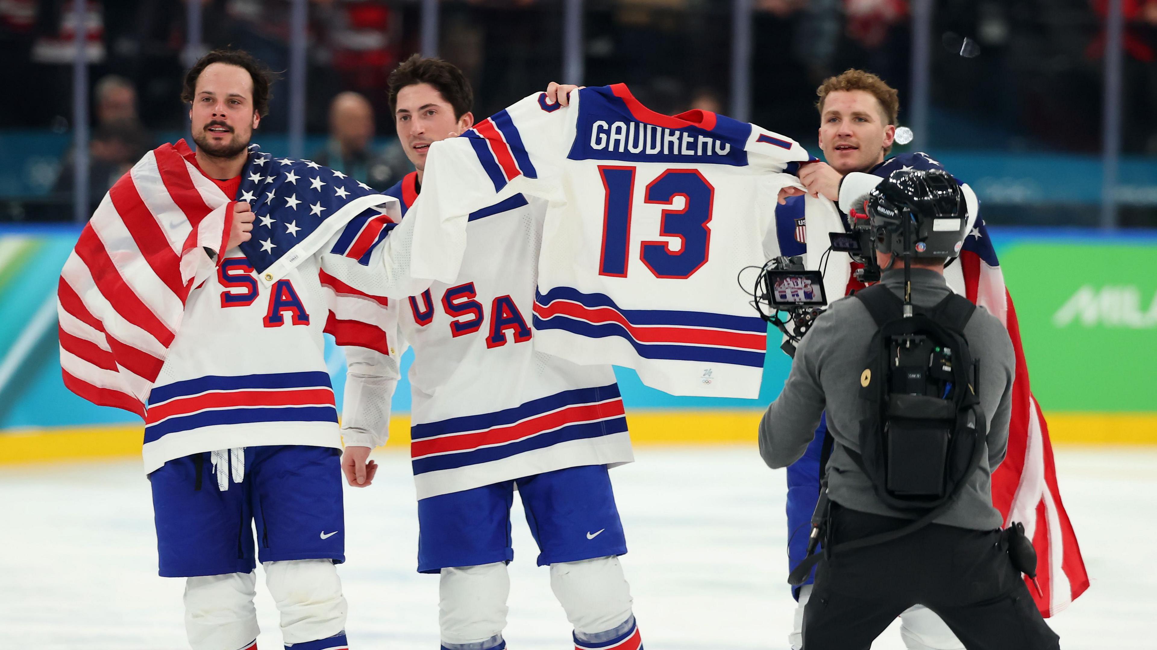 USA players carry the jersey of their late former team mate Johnny Gaudreau on the ice in Milan post-match