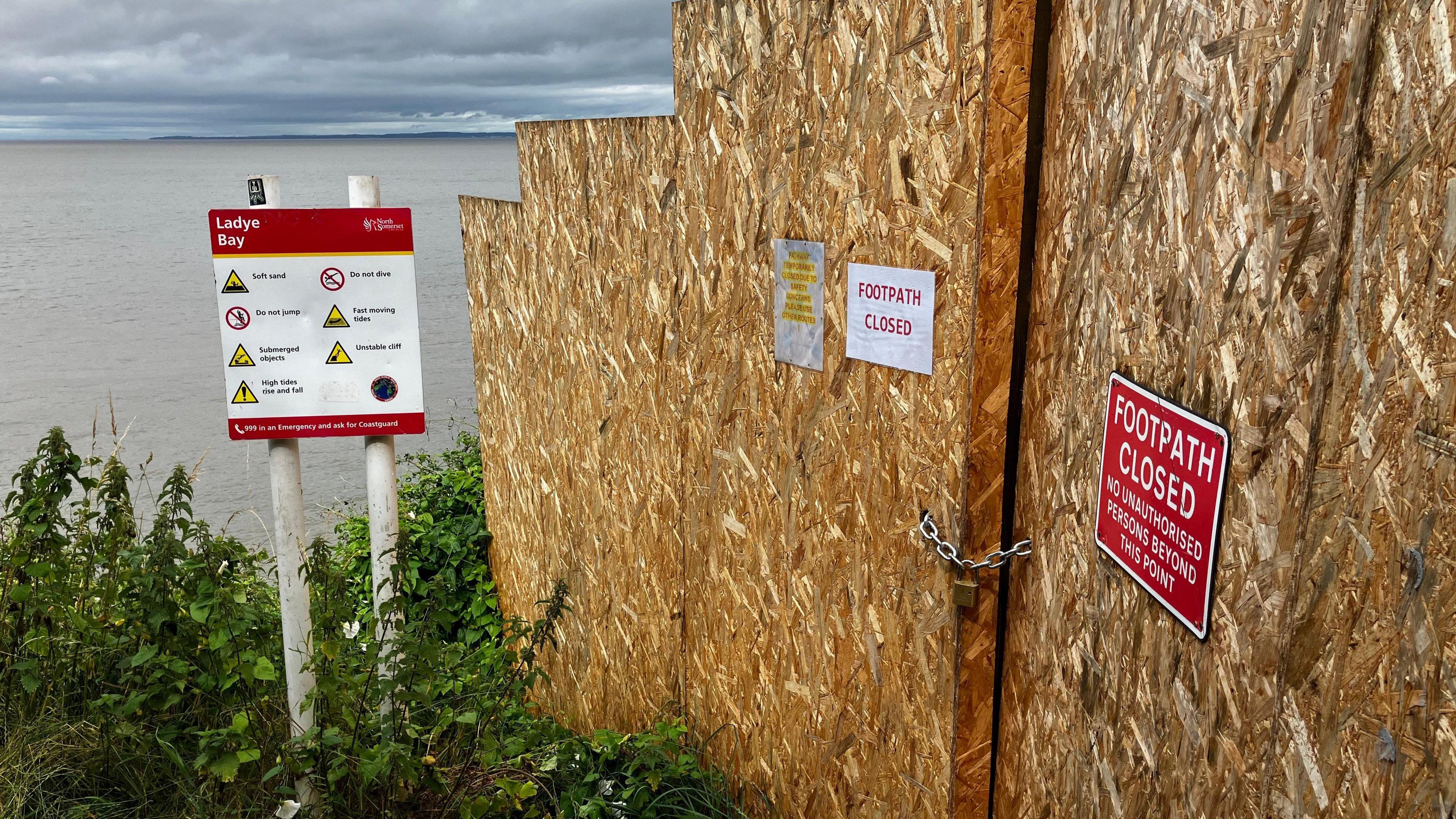 the closed footpath at Ladye Bay in Clevedon. Brown boards are blocking the route, with signs alerting people that the footpath is closed. 