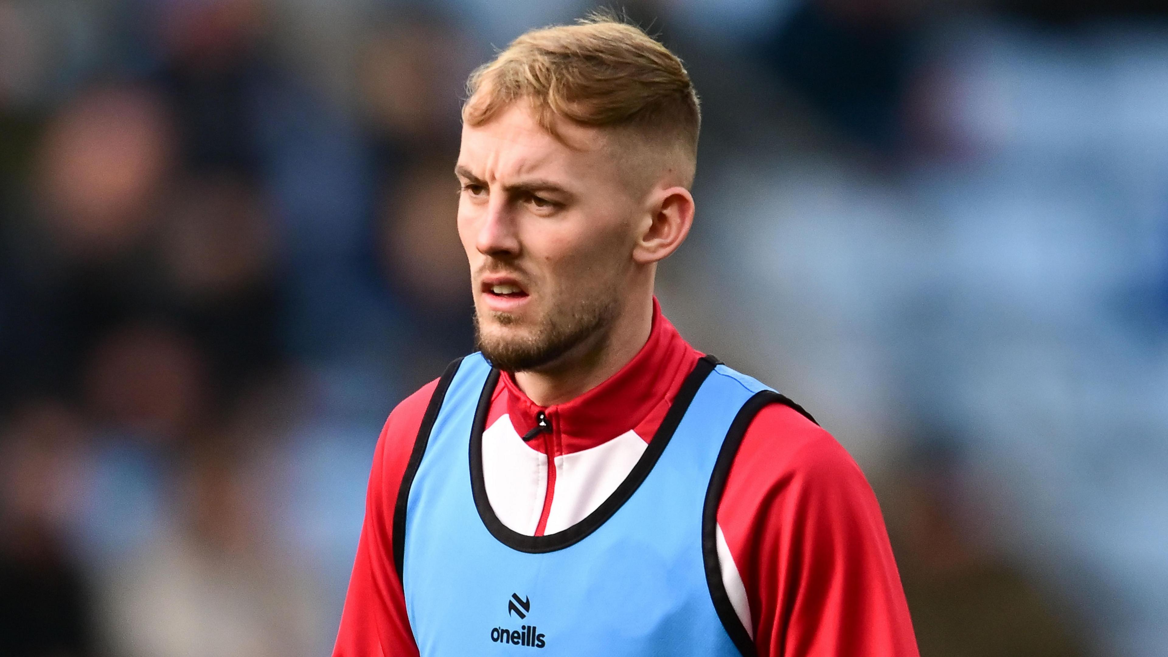 Mark Sykes wearing a blue bib over his Bristol City kit and is standing on the pitch during a pre-match warm-up before the team play Coventry