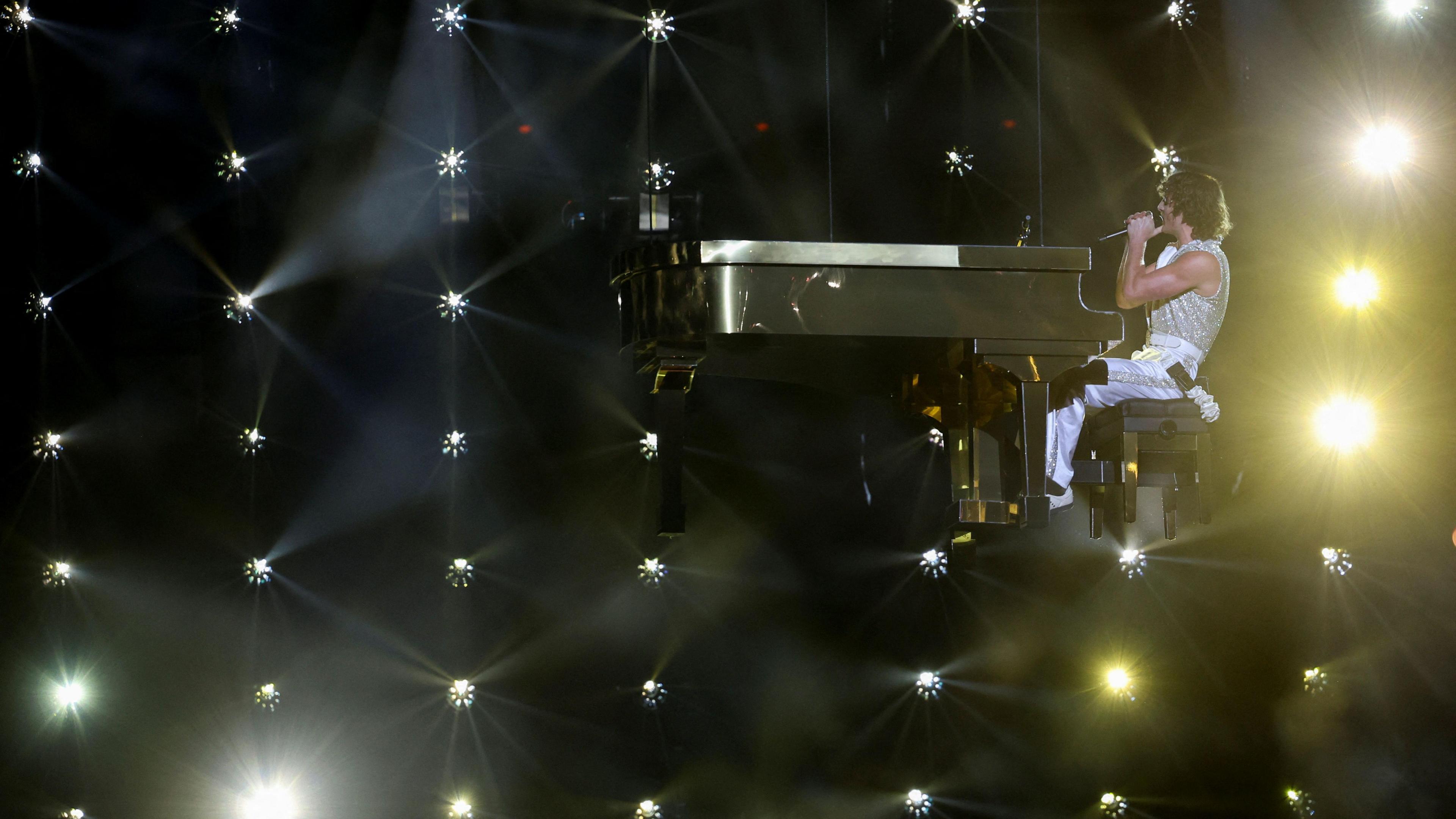 Benson Boone suspended mid-air on a wire sat at a piano during his performance