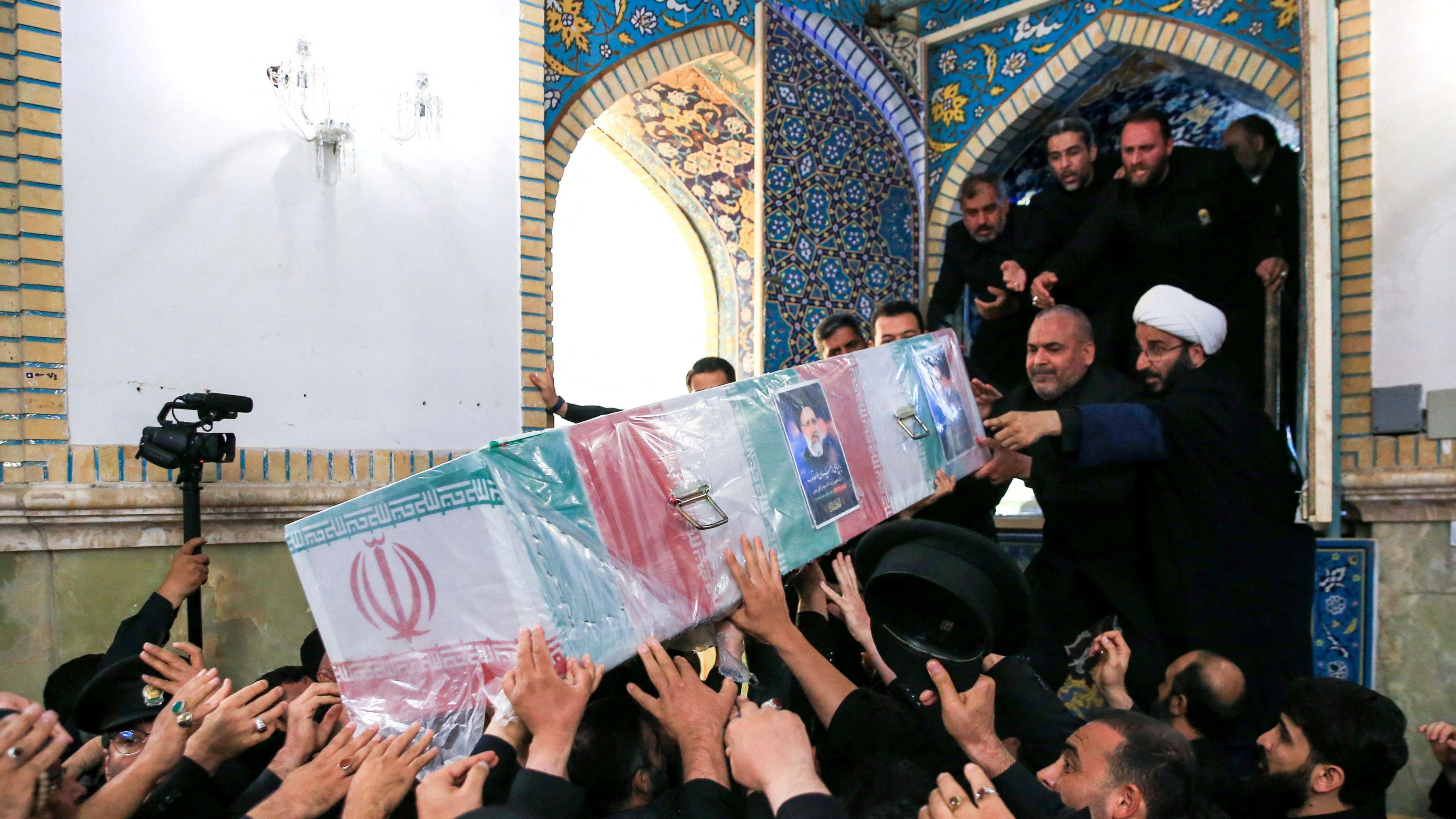 Staff carry the coffin of late Iranian president Ebrahim Raisi during his burial ceremony in the holy shrine of Imam Reza in Mashhad, Iran (23 May 2024)