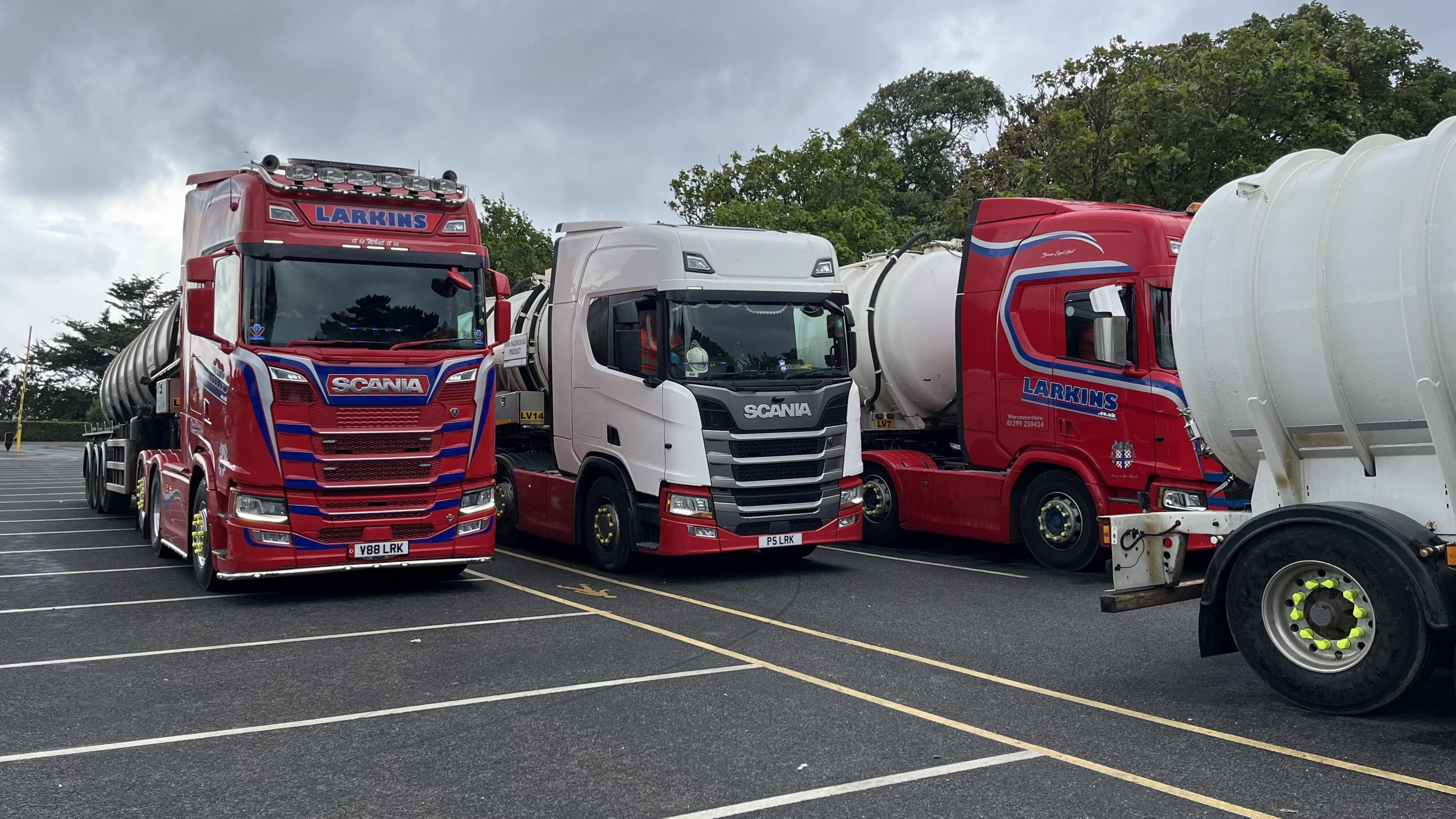 Several sewage lorries in a car park