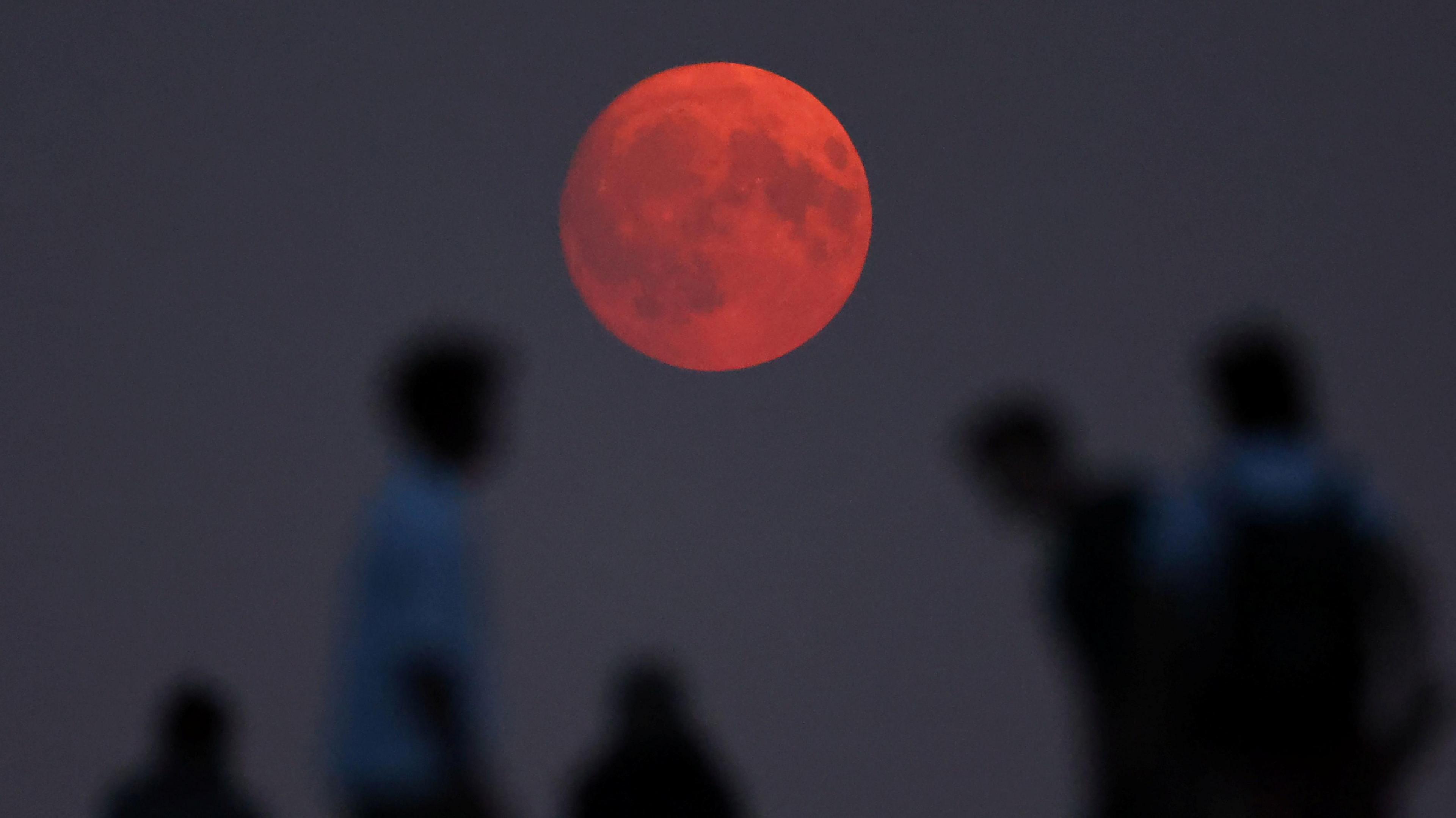 People are seen looking at the supermoon on Sunday night