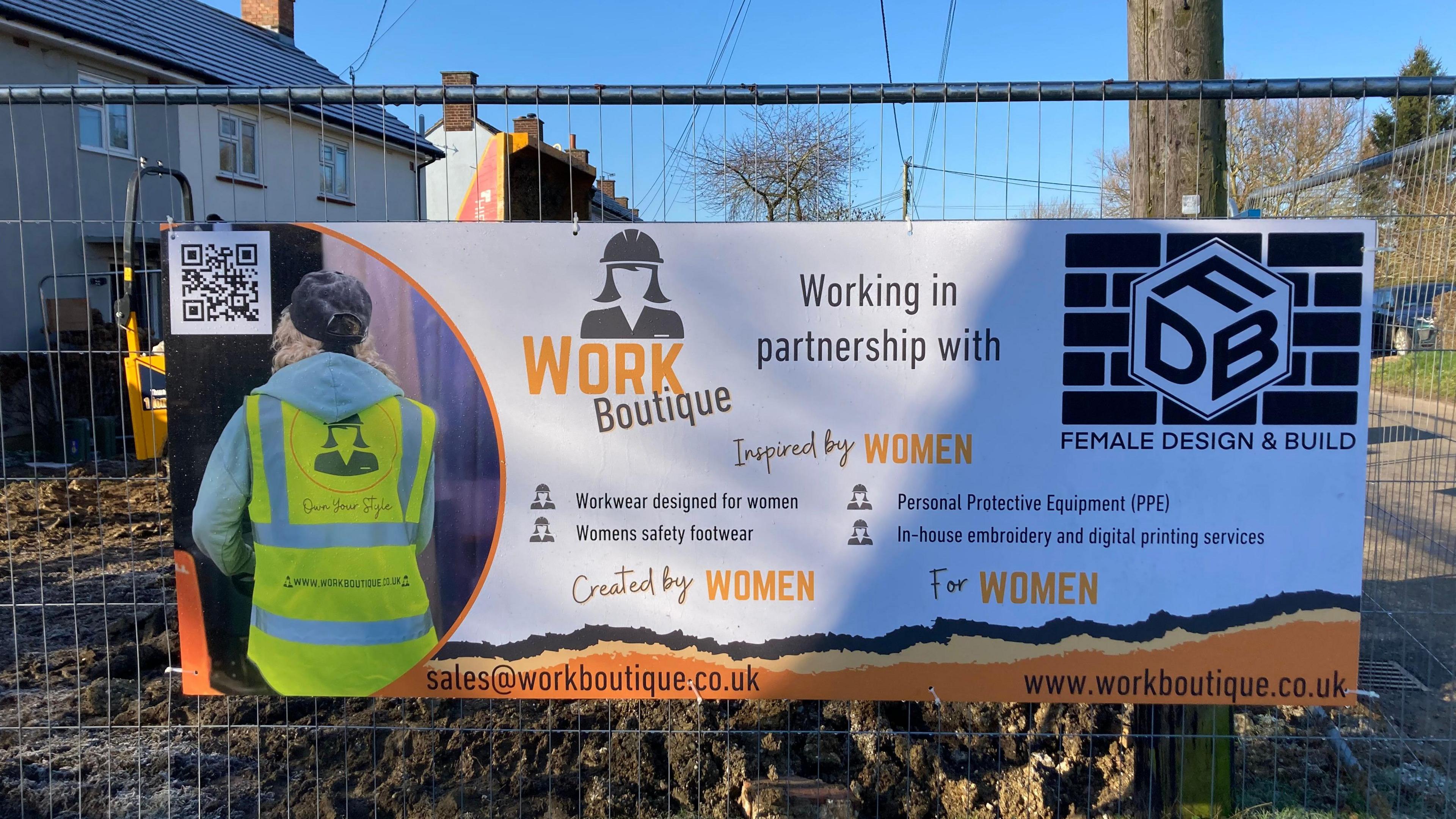 A sign details the information of the project on a metal fence in front of the construction site. 